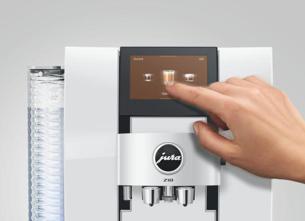 Eine Hand tippt auf den Bildschirm einer Kaffeemaschine, die Getränke anzeigt.