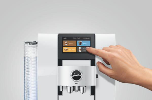 Eine Hand tippt auf den Bildschirm einer Kaffeemaschine, die verschiedene Getränke anzeigt.