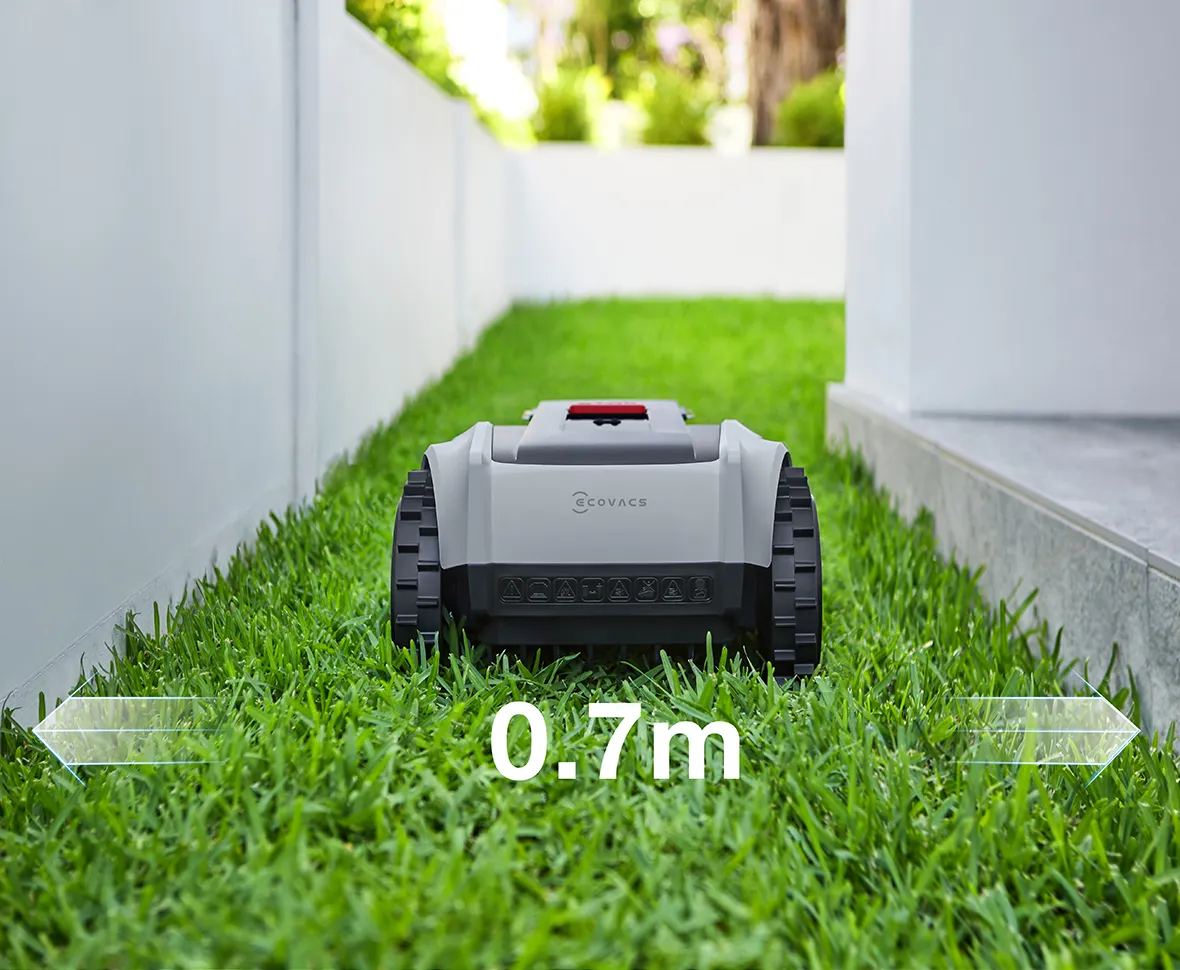Ein Mähroboter auf einem Rasenstreifen zwischen zwei Mauern. 0,7m.