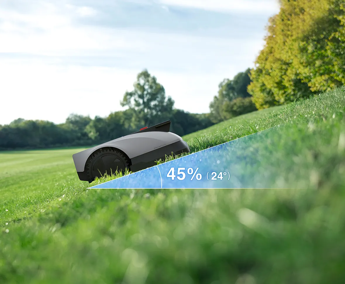 Ein Mähroboter fährt auf einem grünen Hang mit einer Neigung von 45 % (24°).