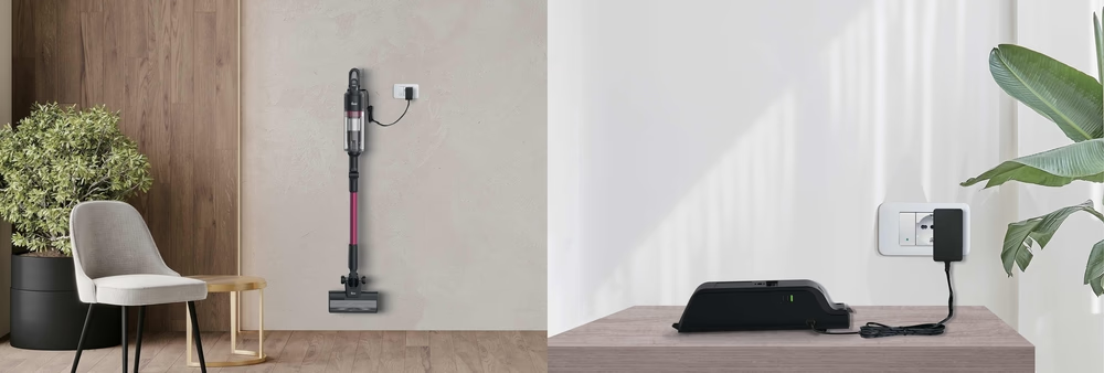 Ein Staubsauger lädt an der Wand, daneben ein Stuhl und eine Pflanze.