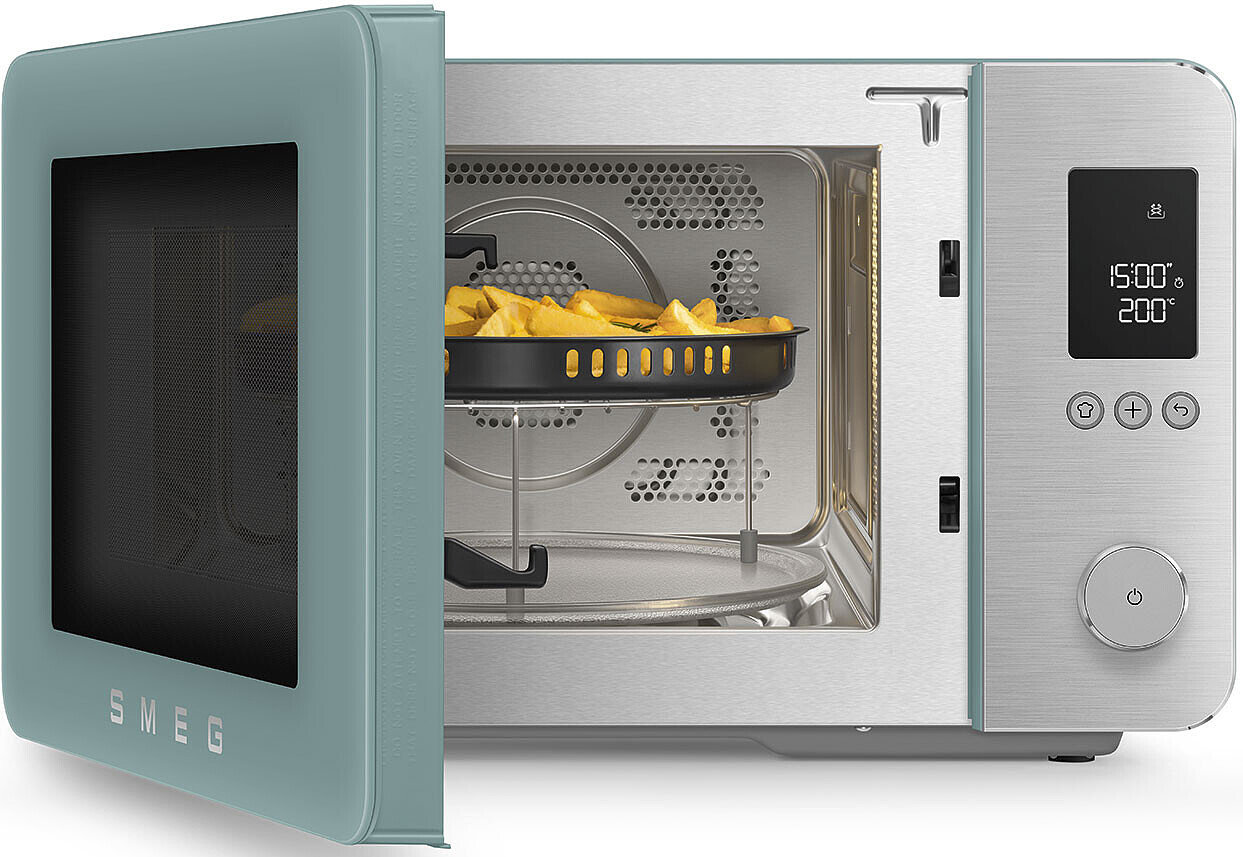 Un four micro-ondes SMEG vert clair, porte ouverte, rempli de frites.