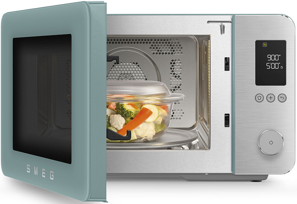 Un four micro-ondes SMEG bleu ouvert avec un plat en verre de légumes.