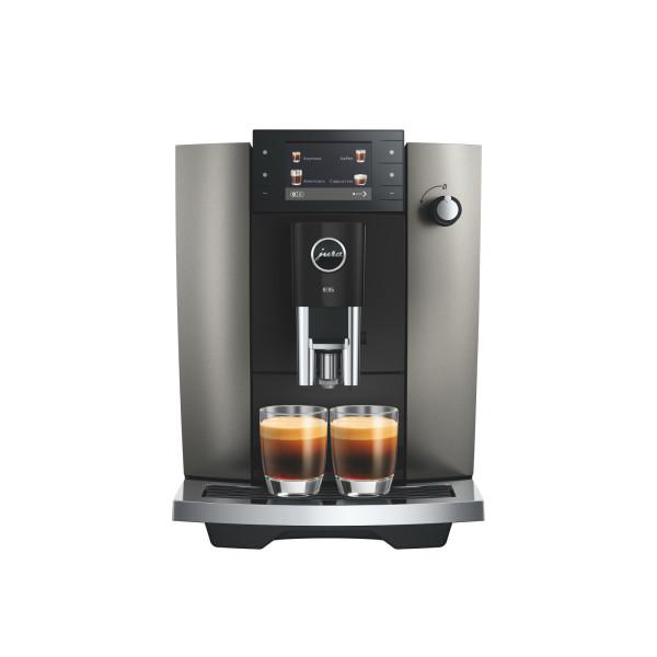 Eine moderne Kaffeemaschine mit zwei Espressogläsern davor.