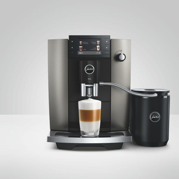 Eine moderne Kaffeemaschine mit Glas und Milchbehälter.
