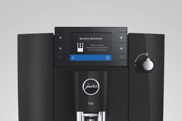 Schwarze Kaffeemaschine mit Bildschirm, der "Quality Assistant" anzeigt.