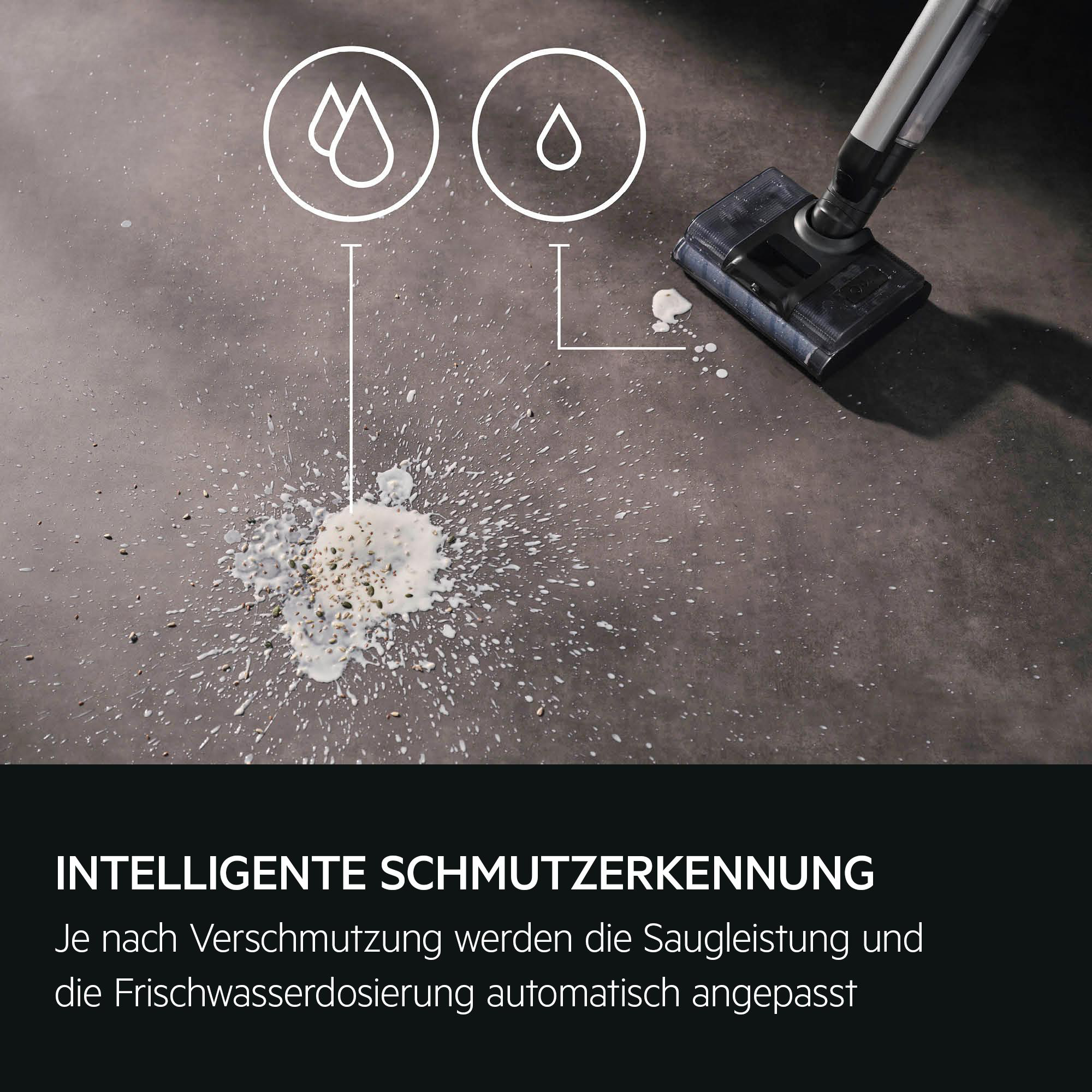 Staubsaugeraufsatz reinigt verschüttetes Essen und Flüssigkeit auf einem dunklen Boden.