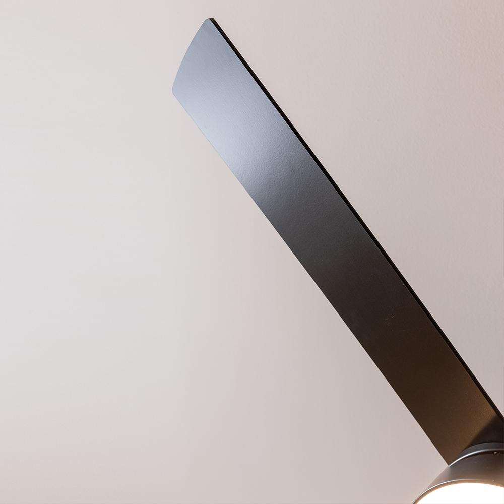 Aspa de ventilador de techo negra en detalle sobre fondo claro.