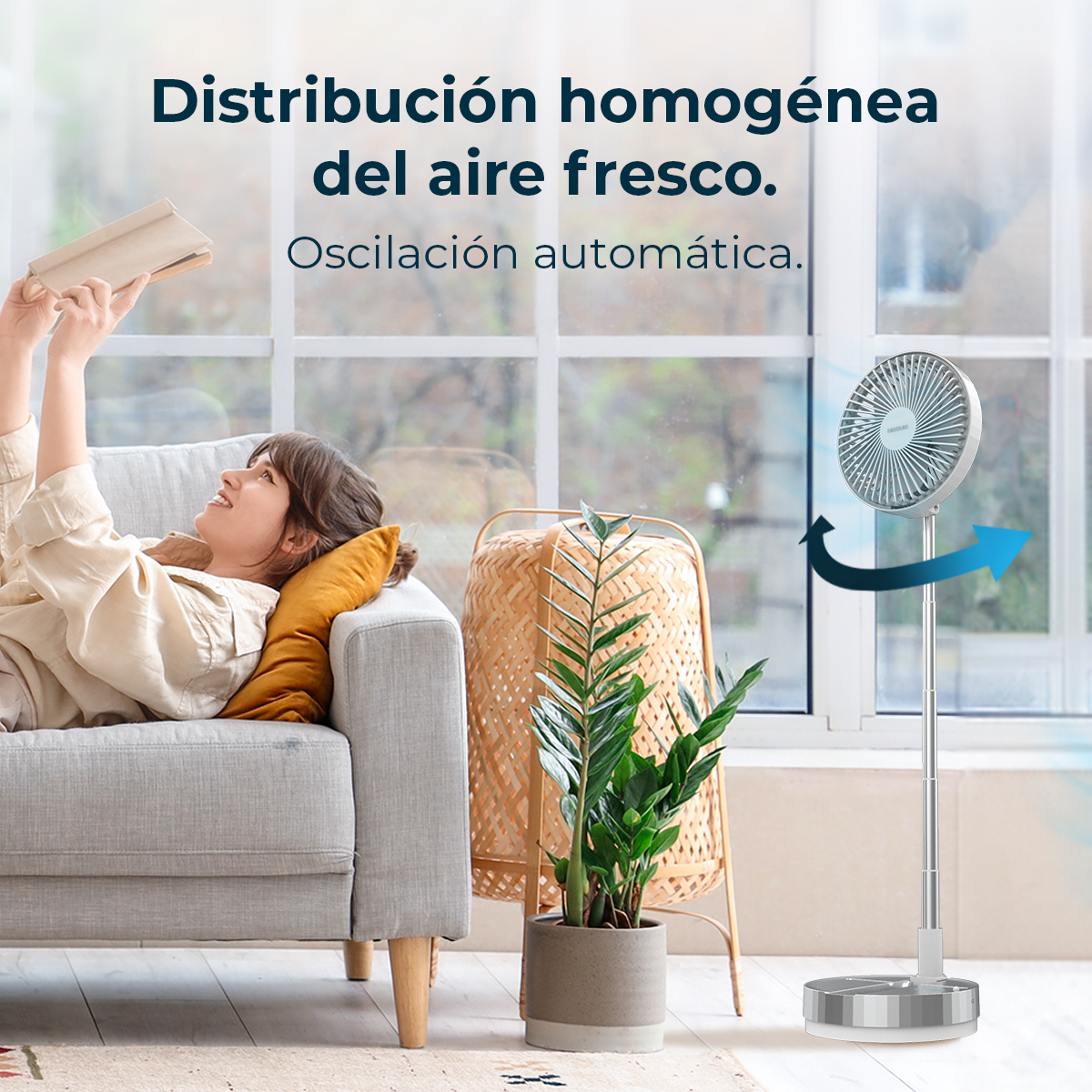 Una mujer lee en un sofá mientras un ventilador oscila al fondo.
