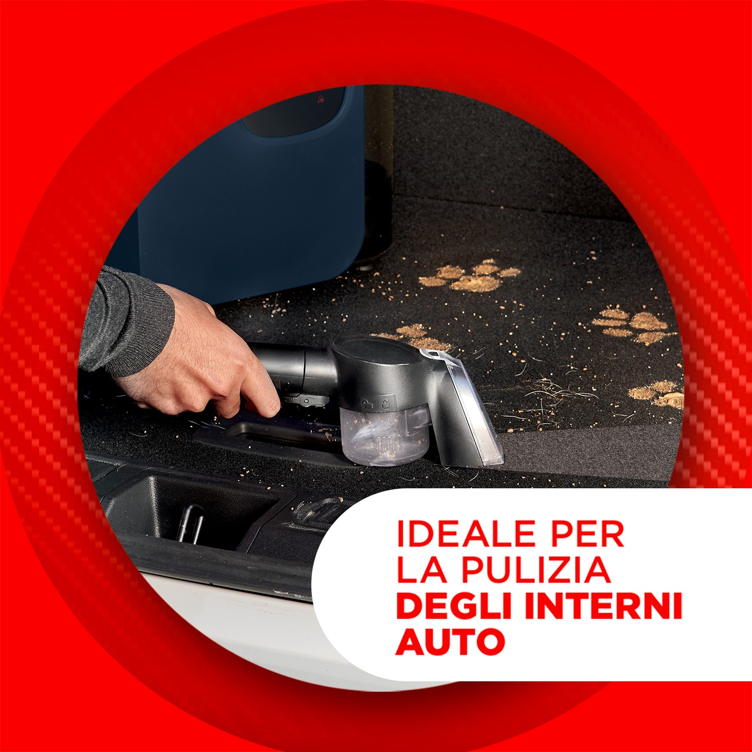 Una persona aspira sporco e impronte di zampe dal tappeto dell'auto.