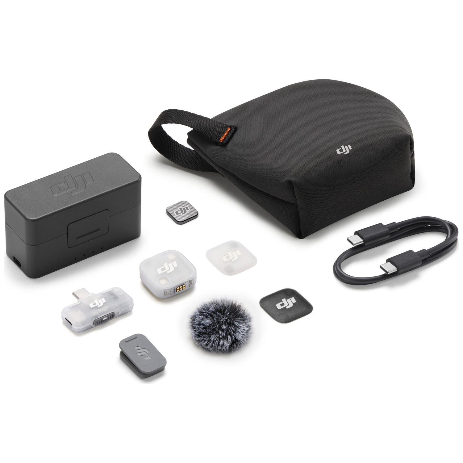Ensemble de microphones DJI avec étui de chargement, bonnette, câble et accessoires sur blanc.