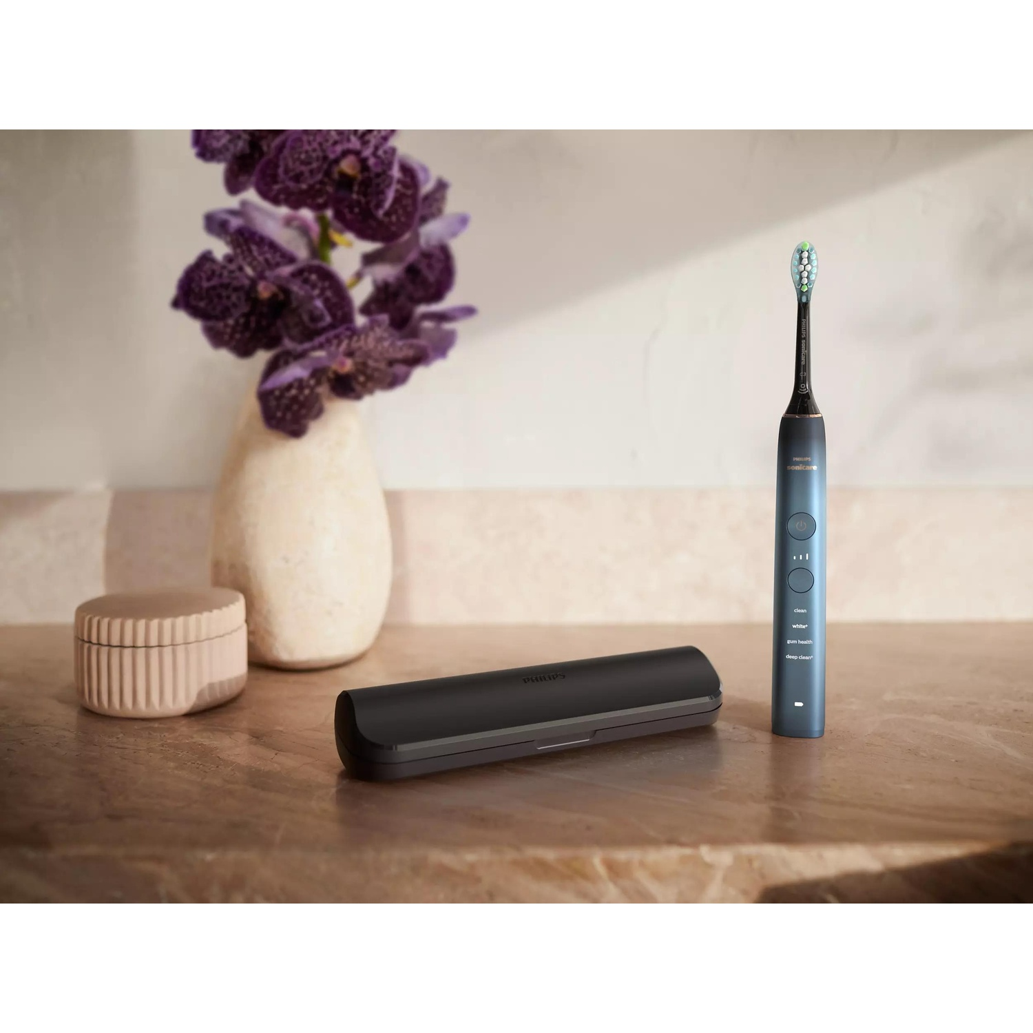 Uno spazzolino Philips Sonicare blu con accenti viola su un piano di pietra.