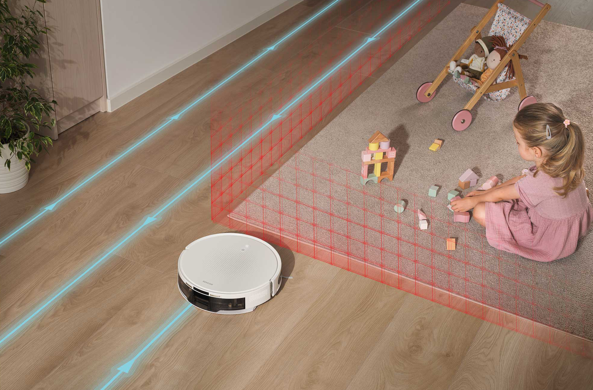 Fehér robotporszívó tisztít keményfa padlót, kislány játszik szőnyegen. Kék vonalak mutatják az utat.