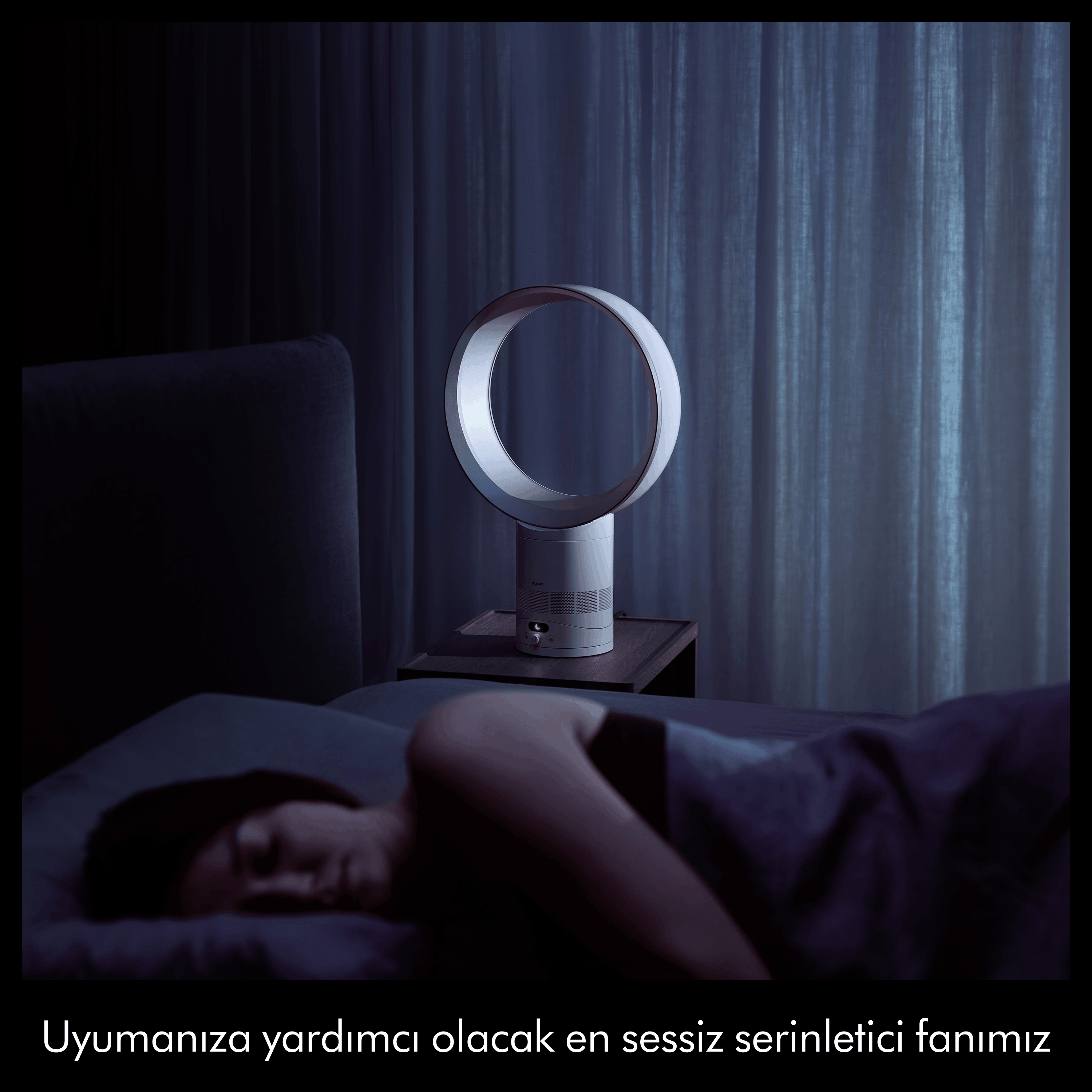 Uyuyan bir kişi, komodinin üzerinde Dyson vantilatör.