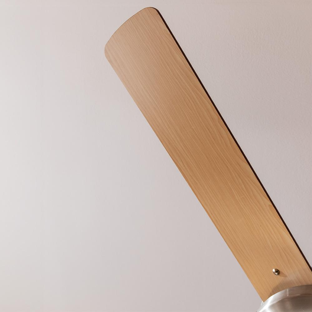 Una pala de ventilador de madera contra un techo blanco. Vista cercana.