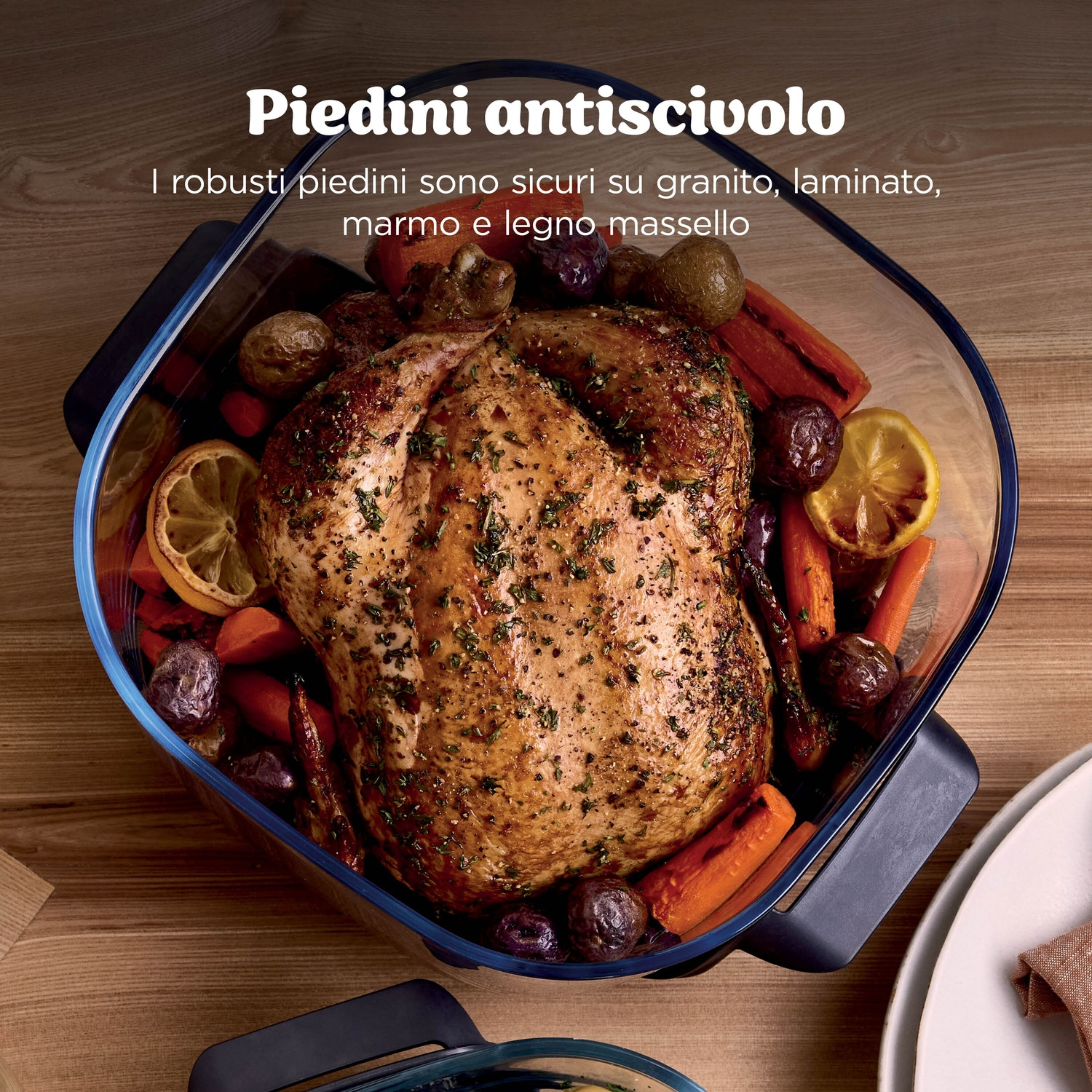 Un pollo arrosto con carote e patate in una pirofila.