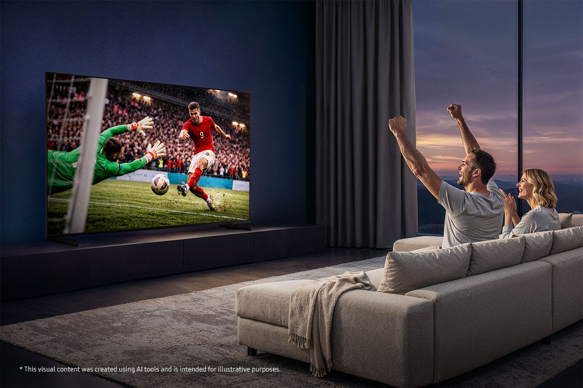 Ein Paar jubelt, während es ein Fußballspiel auf einem großen Fernseher in einem modernen Wohnzimmer sieht.