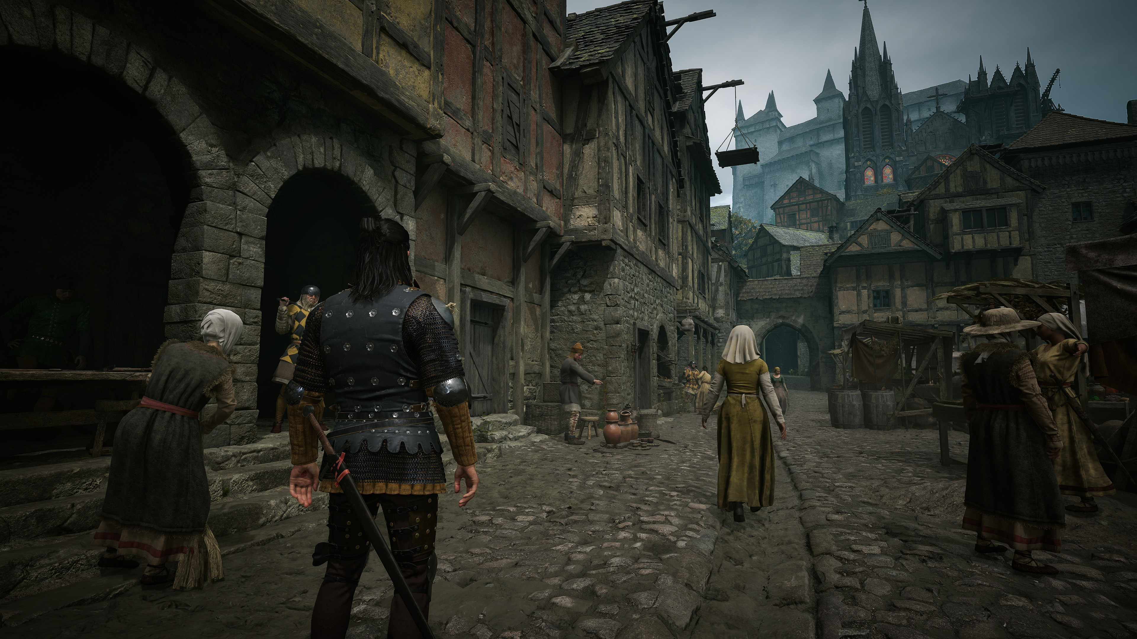 Średniowieczne miasto z ludźmi w historycznych strojach na brukowanej ulicy.