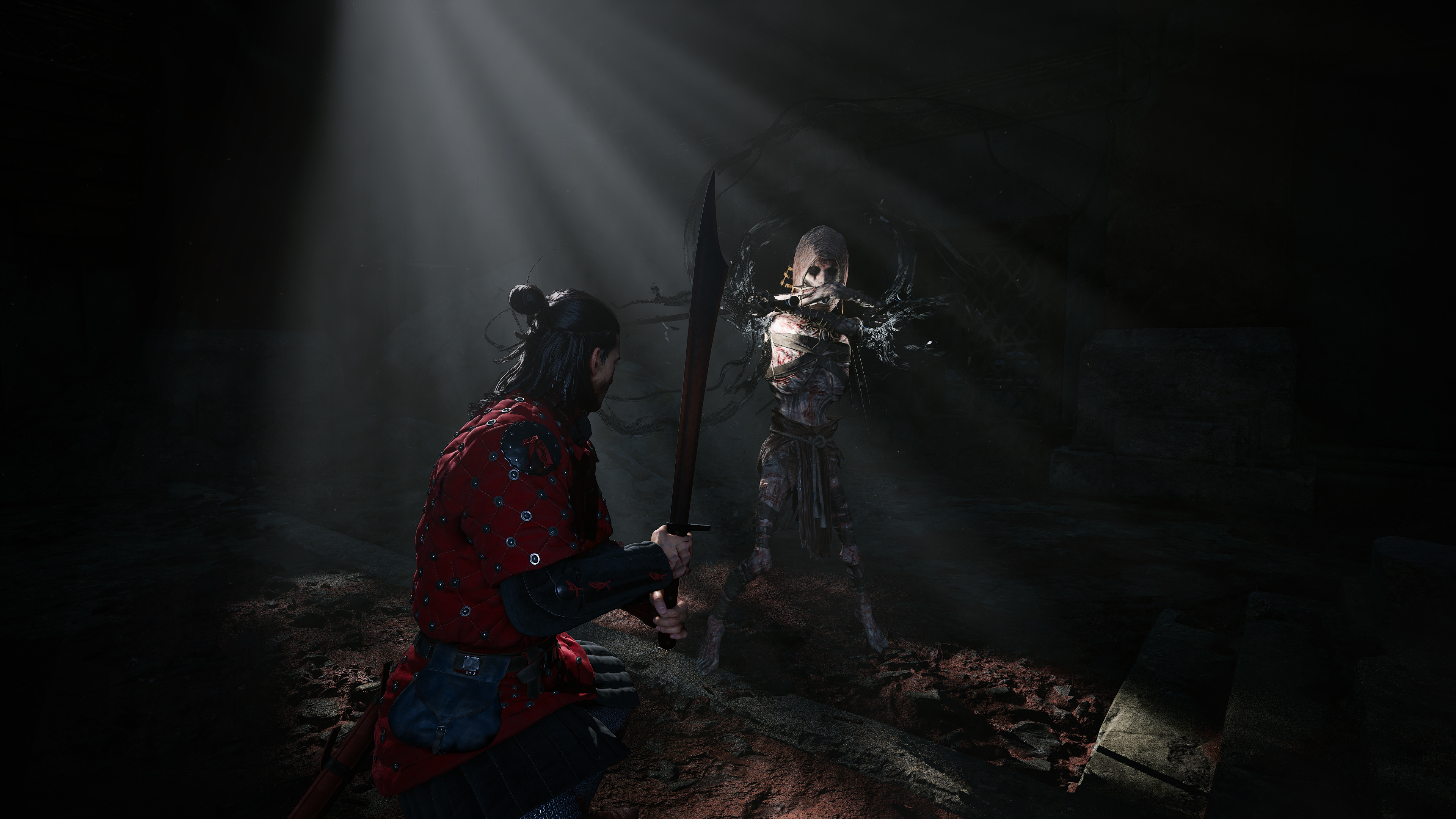 Wojownik w czerwonej zbroi z mieczem staje naprzeciw szkieletowej istoty.