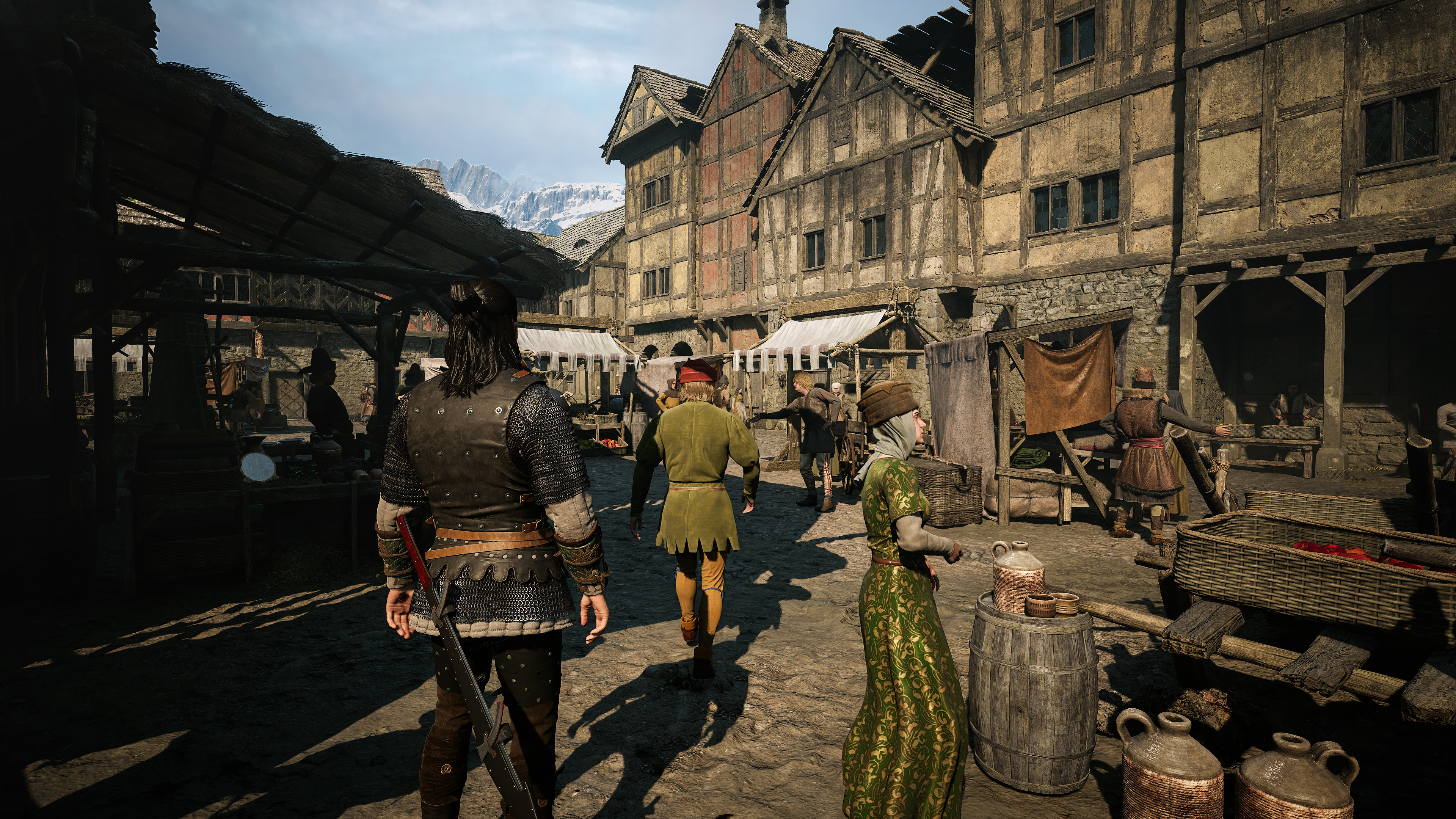 Średniowieczny targ z ludźmi w strojach historycznych i budynkami.