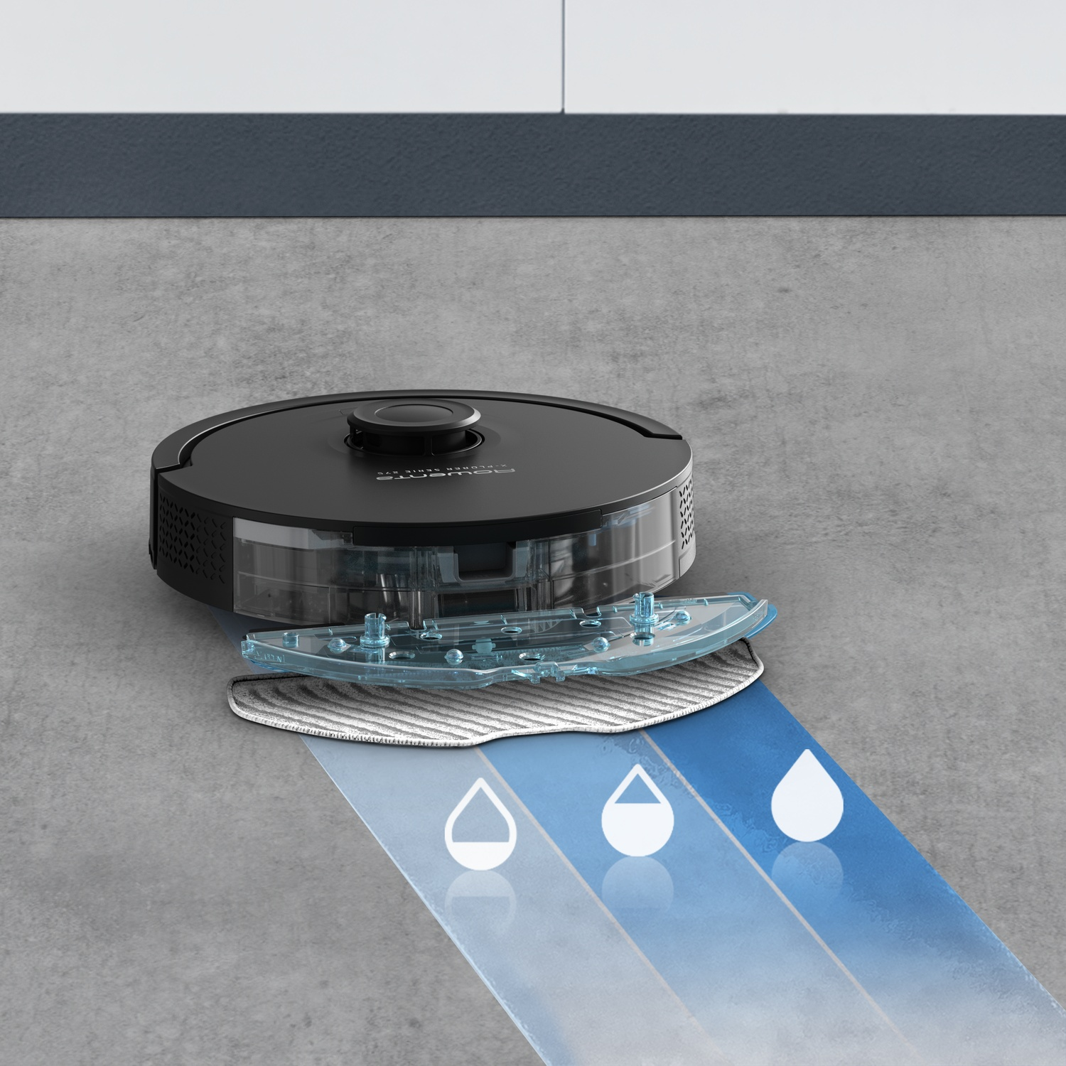A black robot vacuum with a mopping attachment on a concrete floor spraying water.
