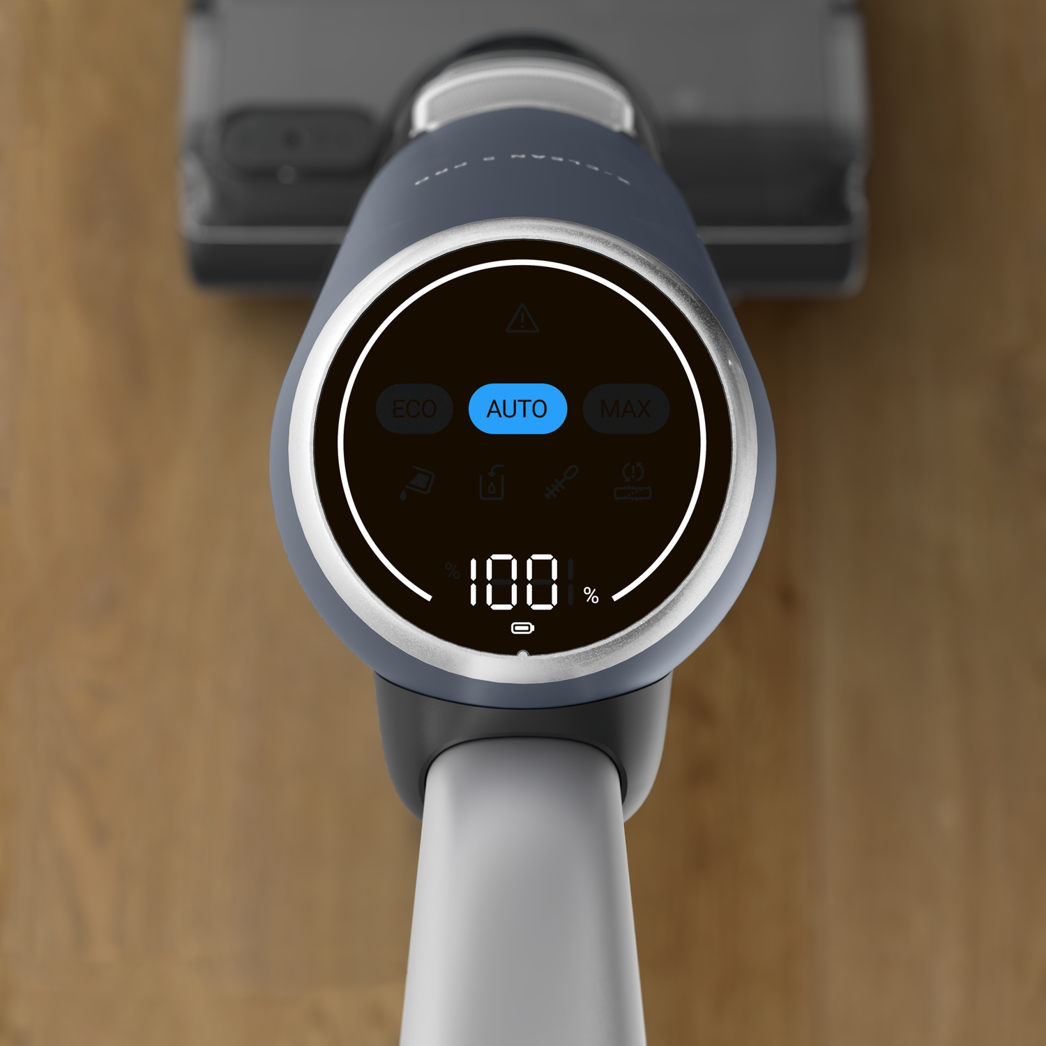 A blue battery indicator shows 100% on a vacuum cleaner display.