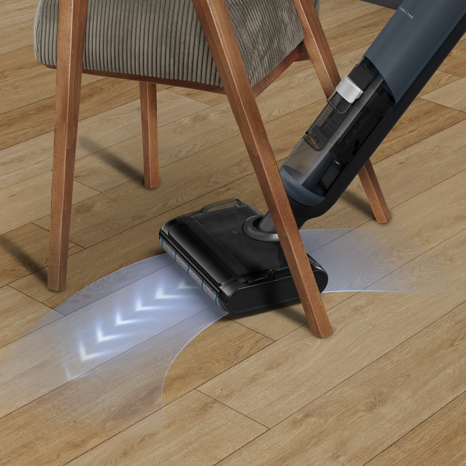 A cordless vacuum cleaner cleans a wood floor next to a chair.