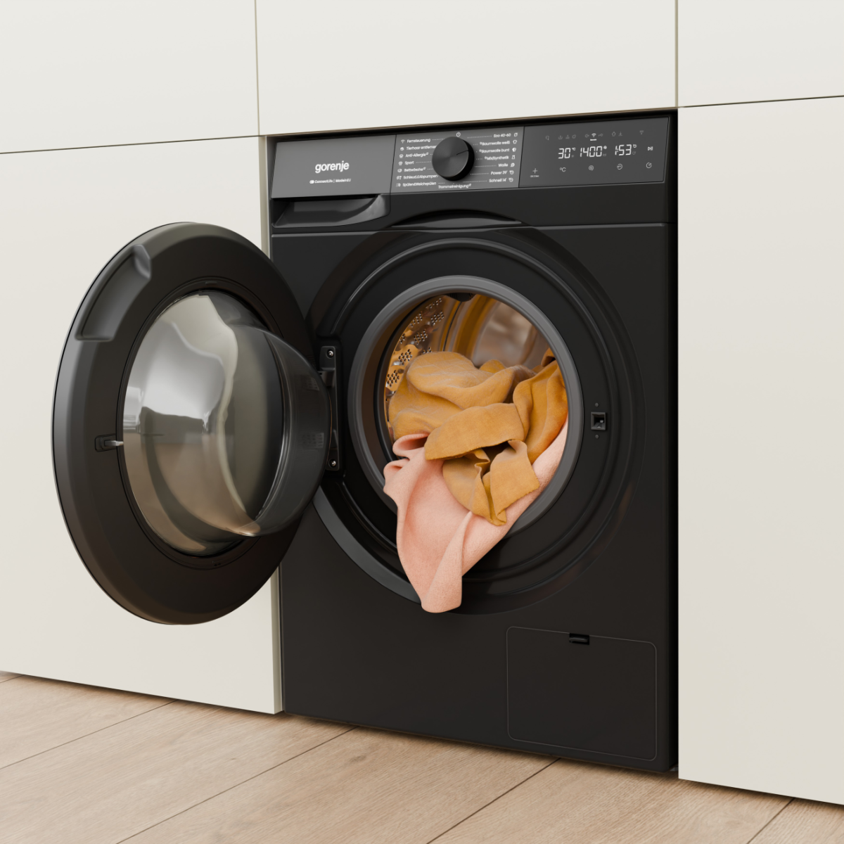 Schwarze Waschmaschine mit offener Tür und darinliegender Kleidung in Orange und Rosa.