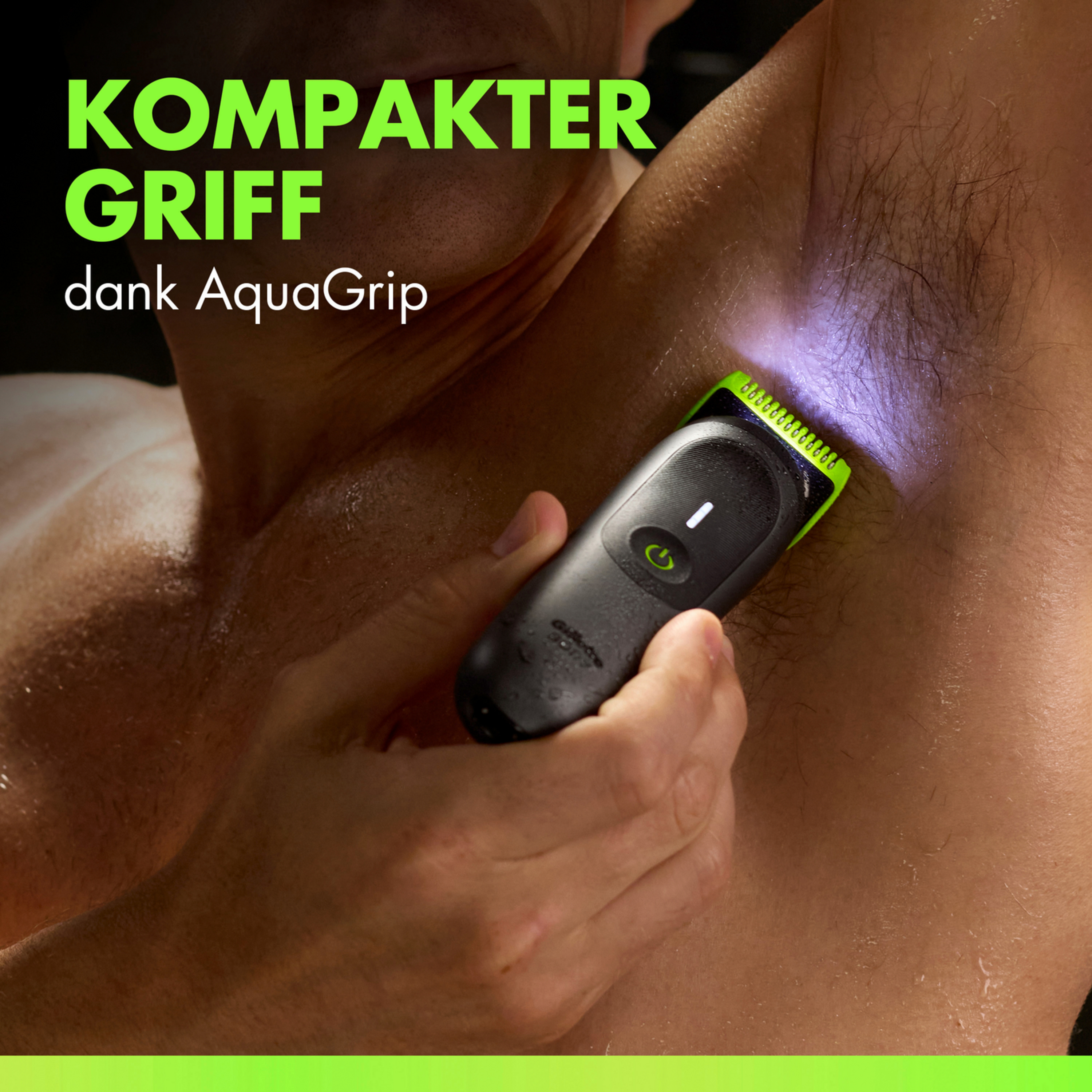 Ein Mann benutzt einen wasserdichten Trimmer im Achselbereich, beleuchtet von blauem Licht.