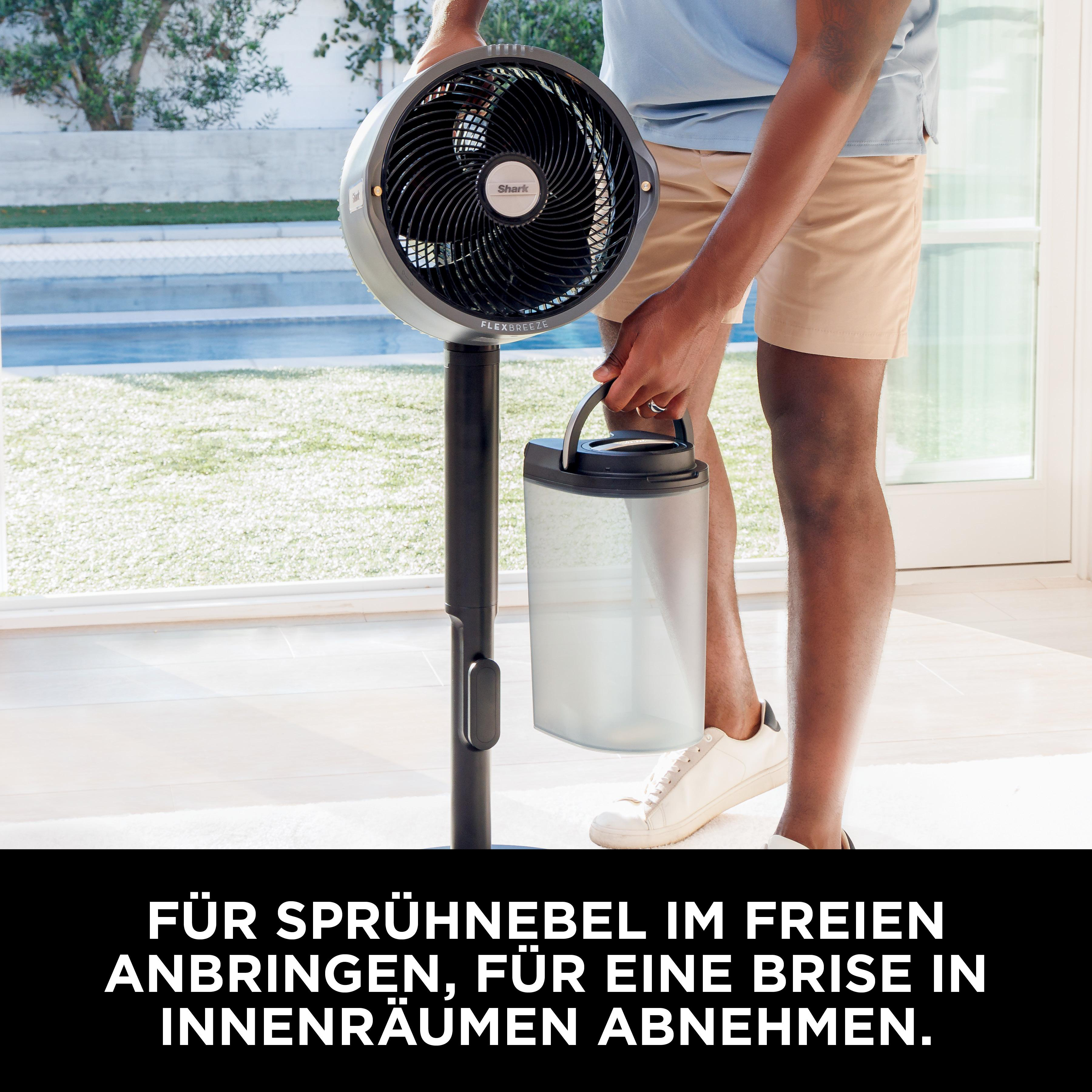 Ein Mann hält einen transparenten Tank für einen Ventilator im Freien.