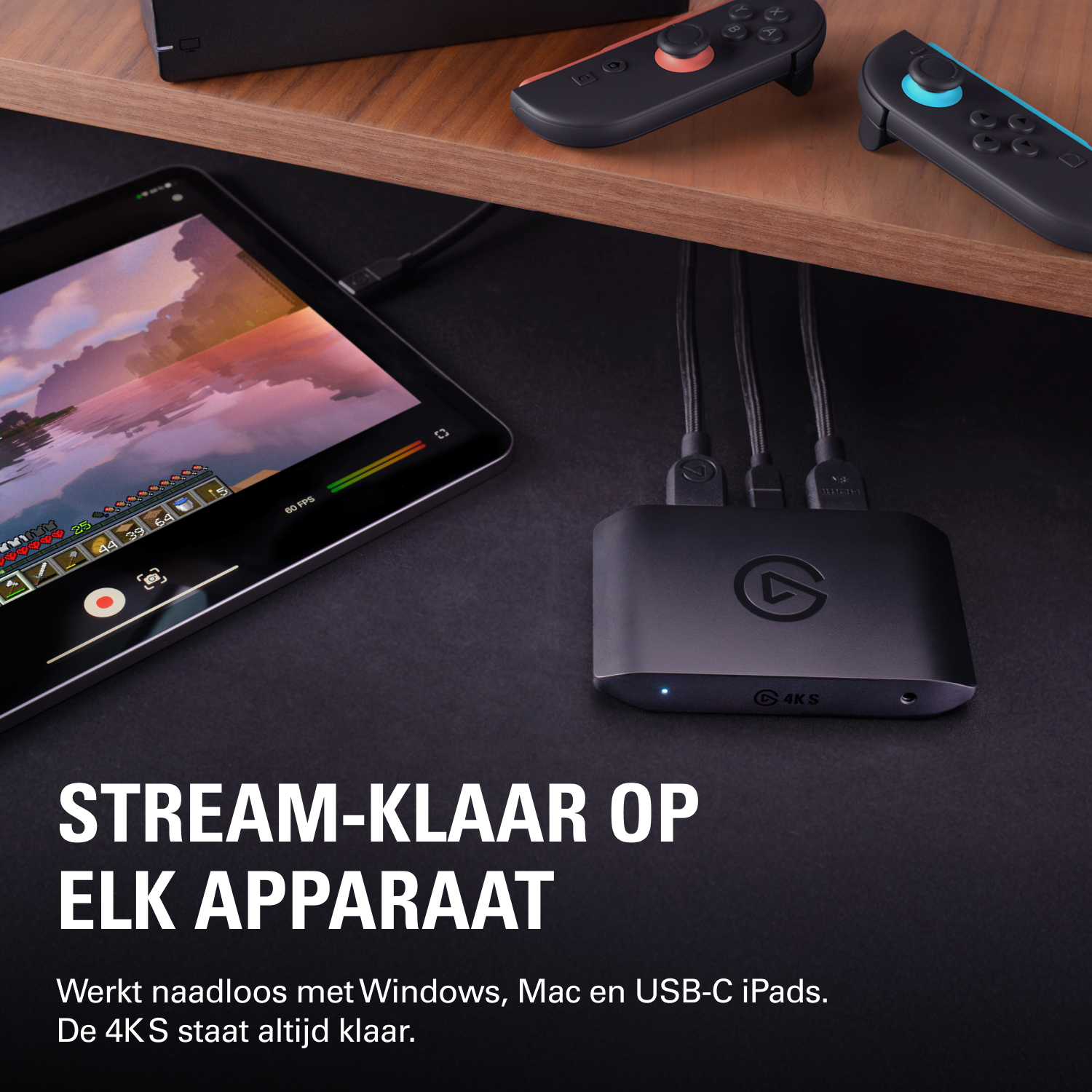 Zwarte capture box met drie kabels, tablet met spel en controllers.