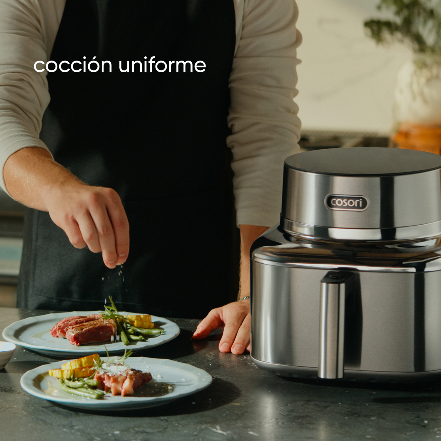 Un hombre sazona carne en platos junto a un electrodoméstico plateado.