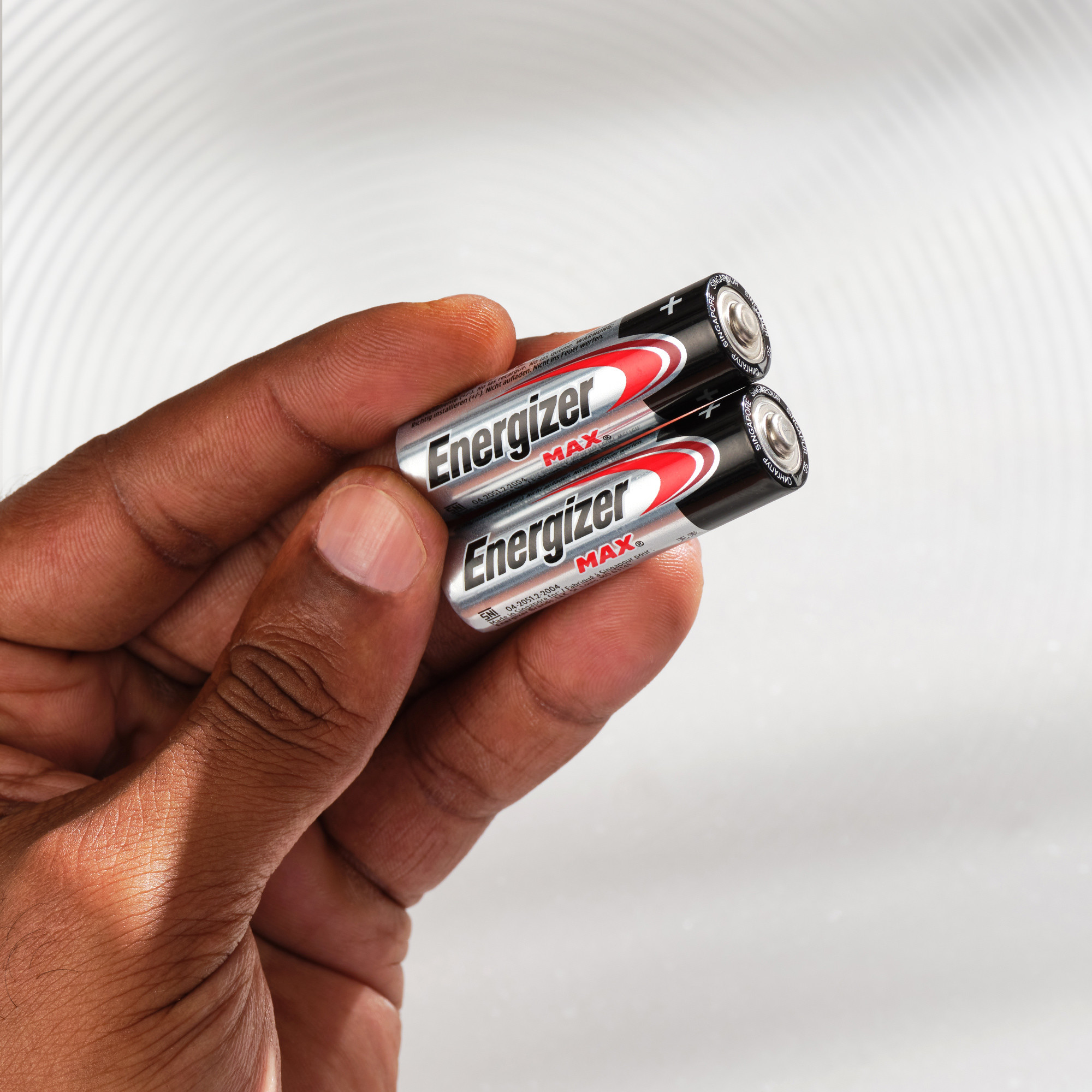 Eine Hand hält zwei Energizer Max AA-Batterien.