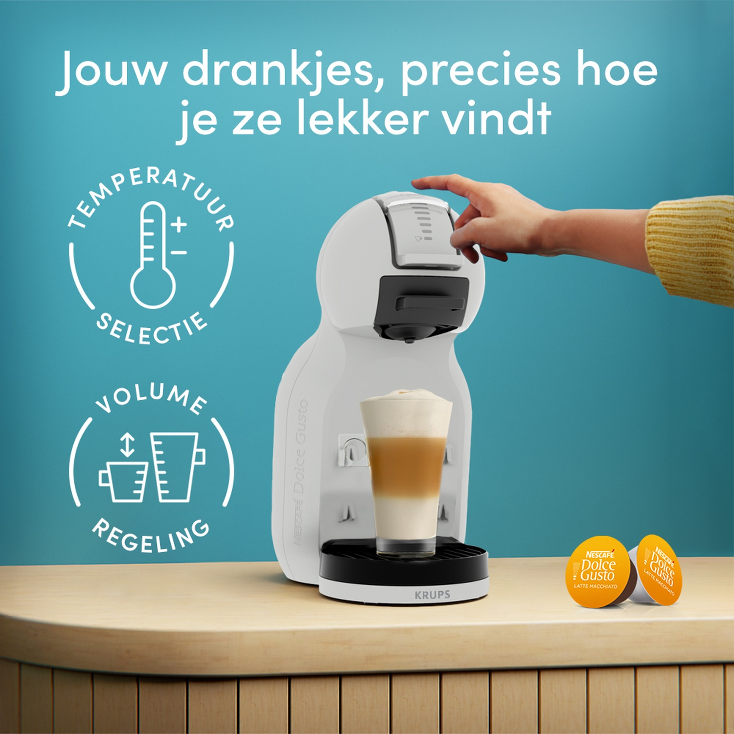 Witte koffiemachine met een glas latte macchiato en cups.