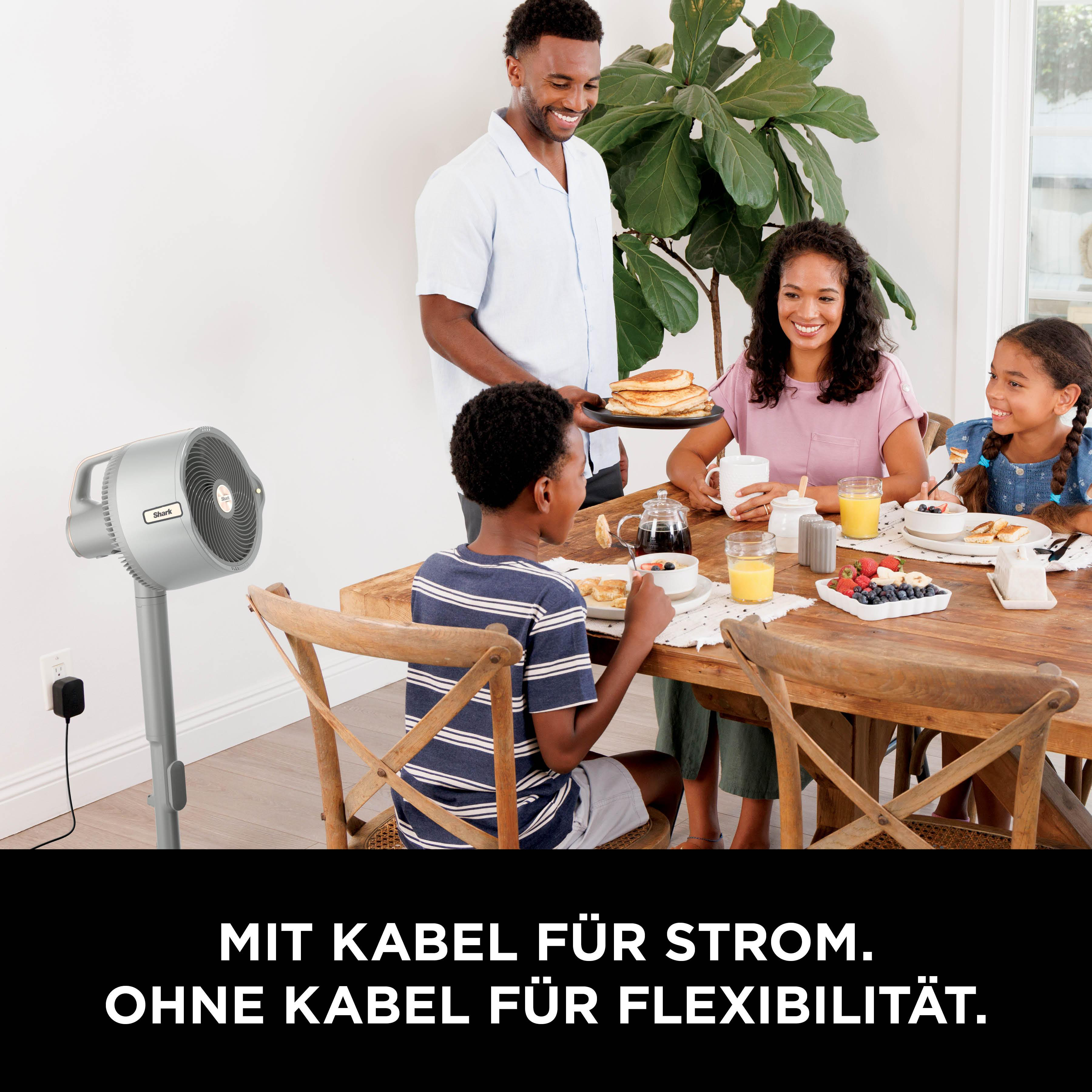 Familie beim Frühstück, mit einem Lüfter im Hintergrund.