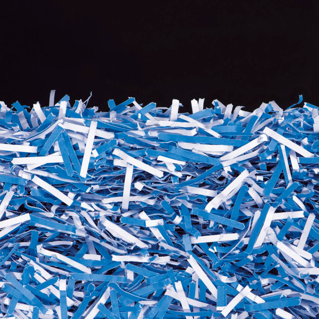 Blau-weiße Papierschnipsel mit schwarzem Hintergrund.