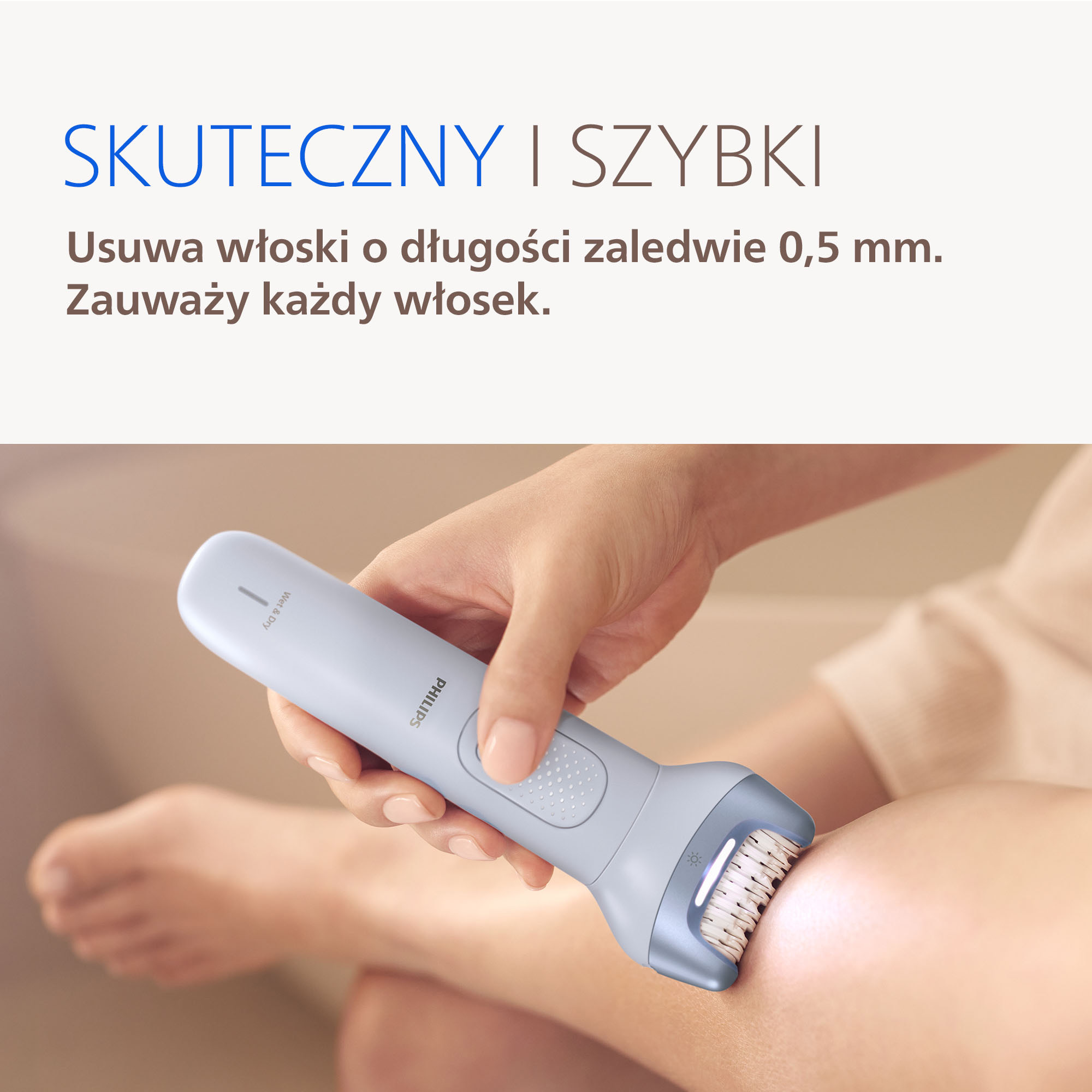 Dłoń trzyma jasnoniebieski depilator Philips na powierzchni skóry.