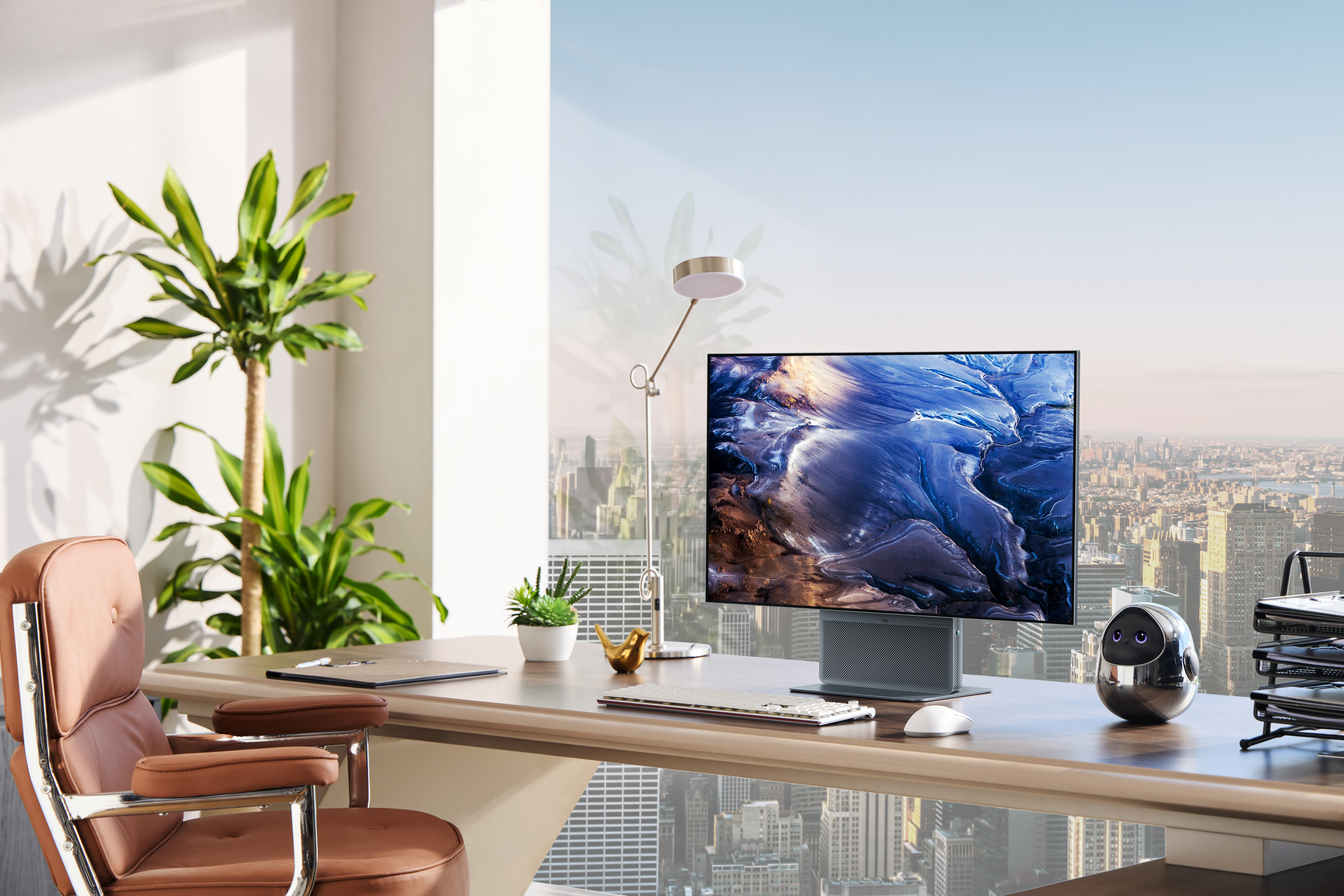 Büro mit Schreibtisch, Stuhl, Monitor, Lampe und Stadtblick.