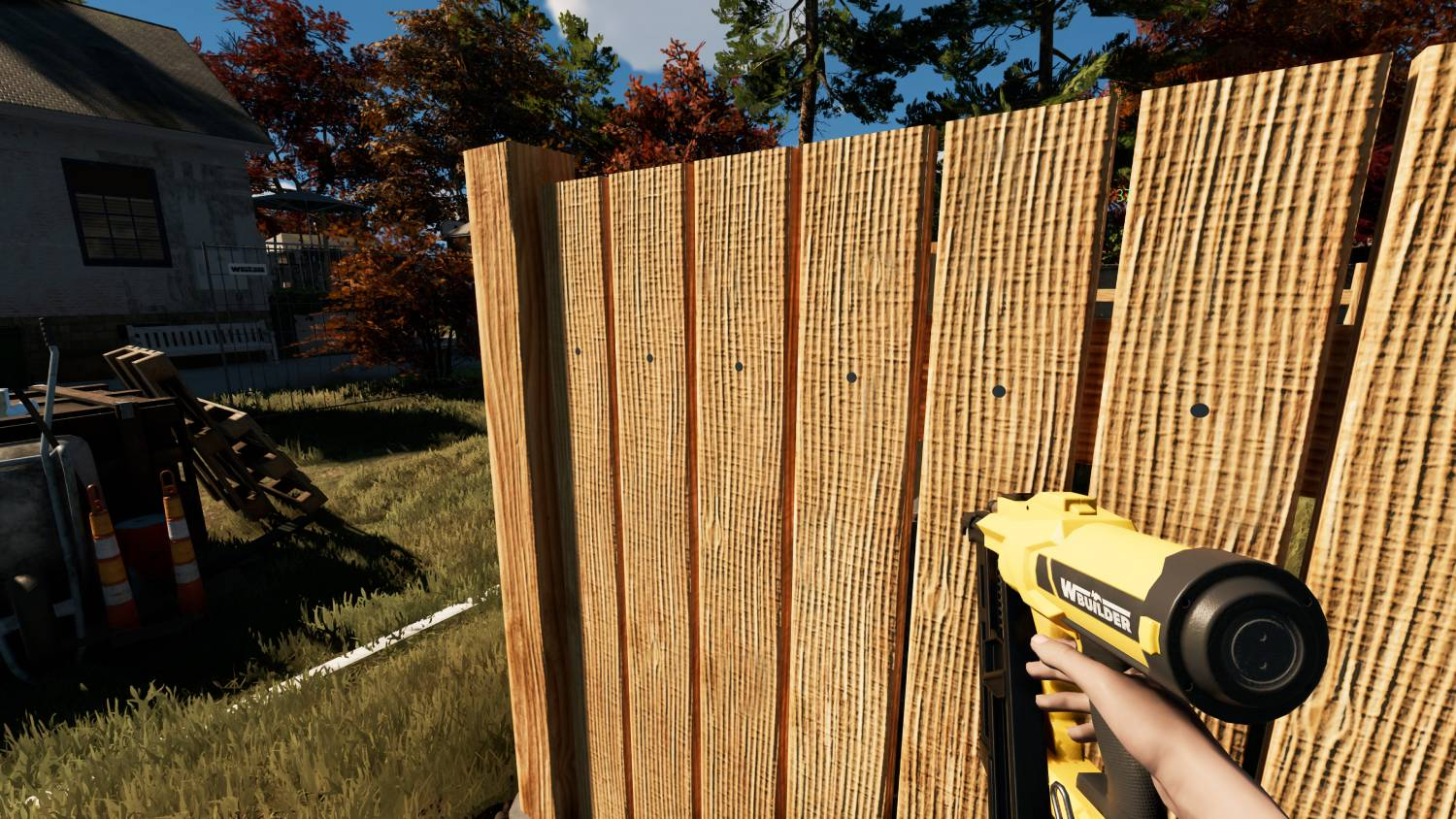 Una mano usa una pistola de clavos amarilla para construir una valla de madera.