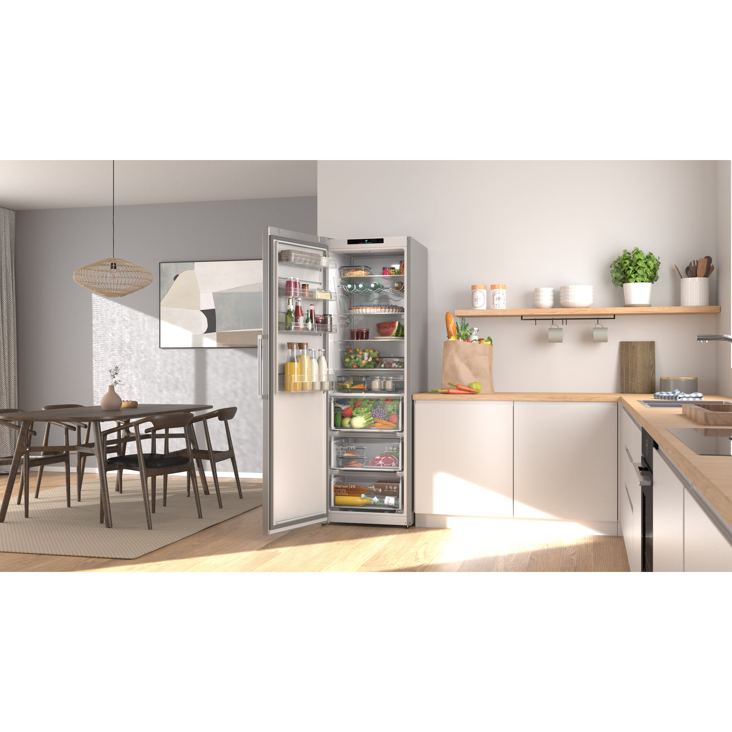 Modern kitchen with open refrigerator filled with food. Dining area with wooden table and chairs.