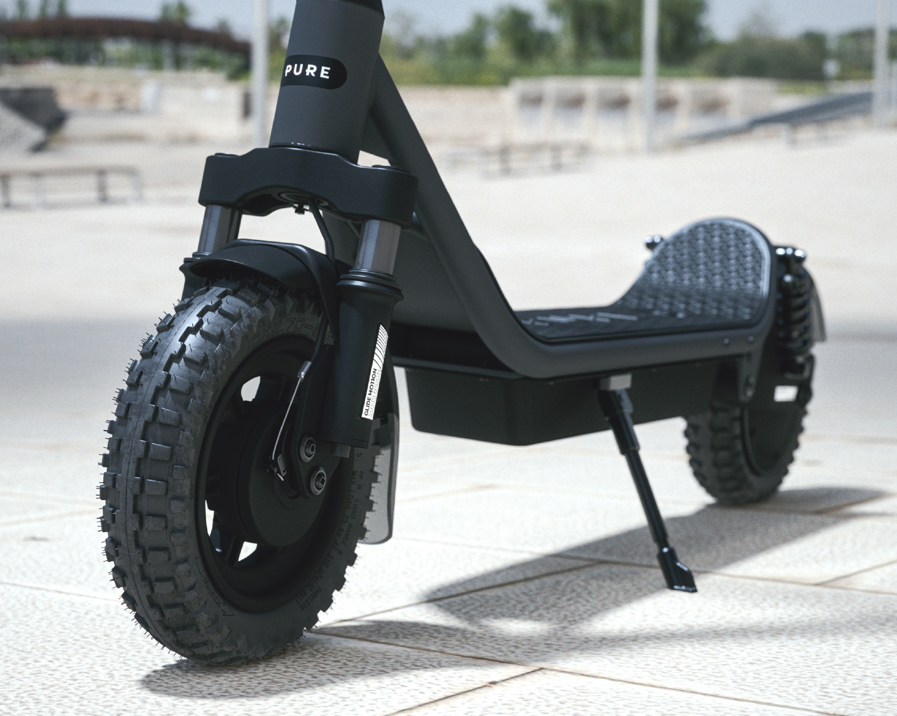 Ein schwarzer E-Scooter mit grobstolligen Reifen steht auf einem Gehweg.