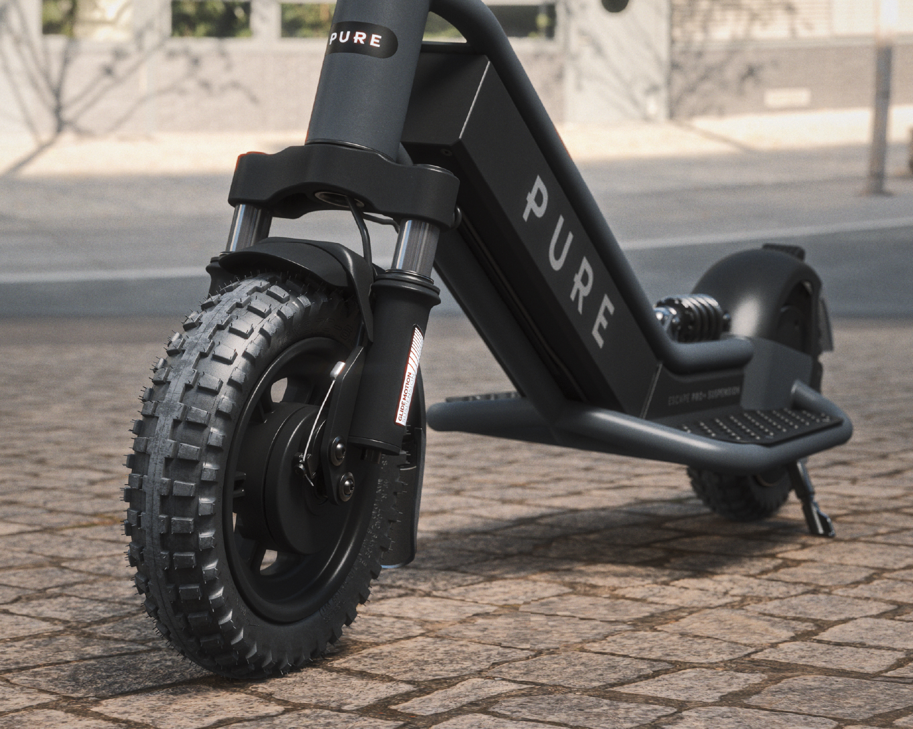 Ein schwarzer E-Scooter mit großen Reifen auf Kopfsteinpflaster.