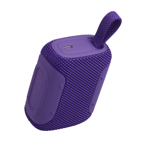 Lila hangszóró hordozópánttal és USB-C porttal, fekete háttéren.