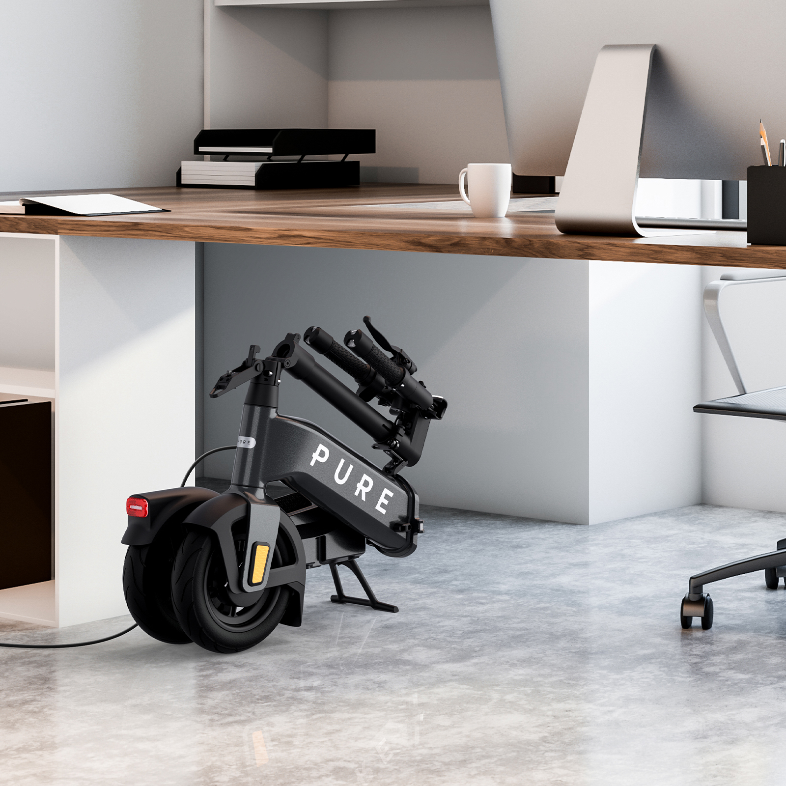 Ein grauer E-Scooter steht unter einem Schreibtisch. Ein Bürostuhl ist rechts.