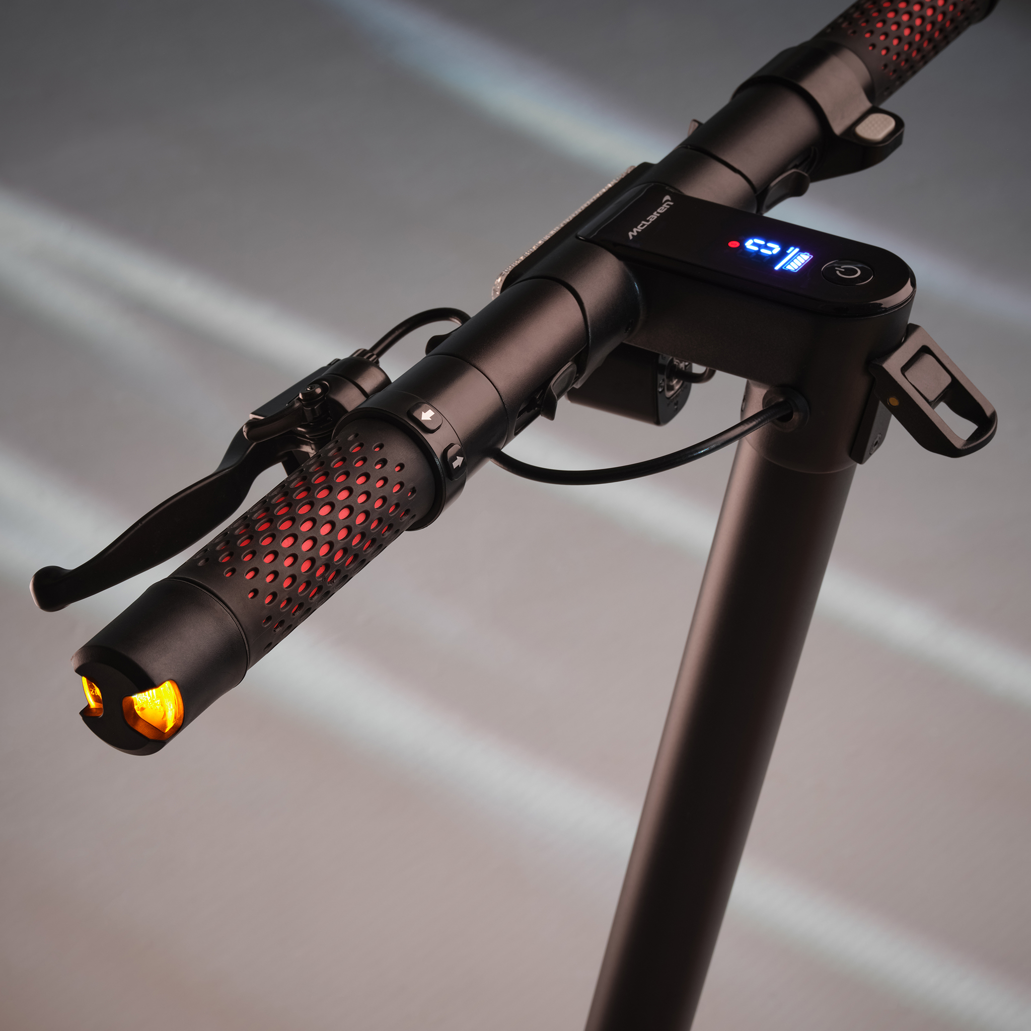 Schwarzer E-Scooter Lenker mit rotem Muster, Display und Licht.