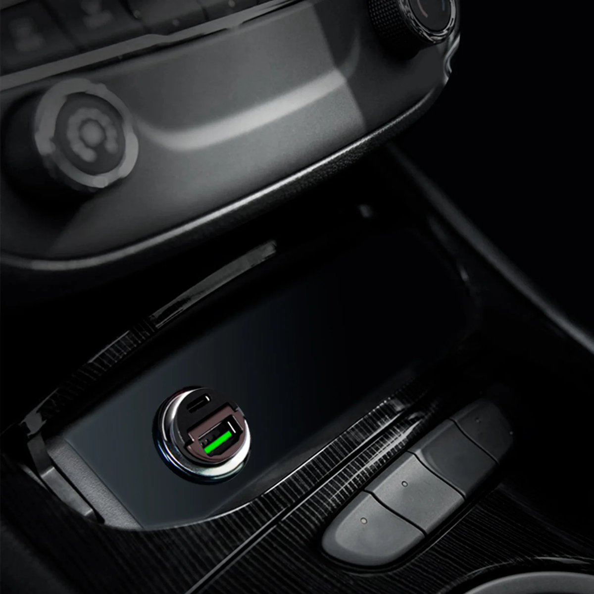 Ein schwarzer USB-Adapter mit grünem Licht in einem Auto.