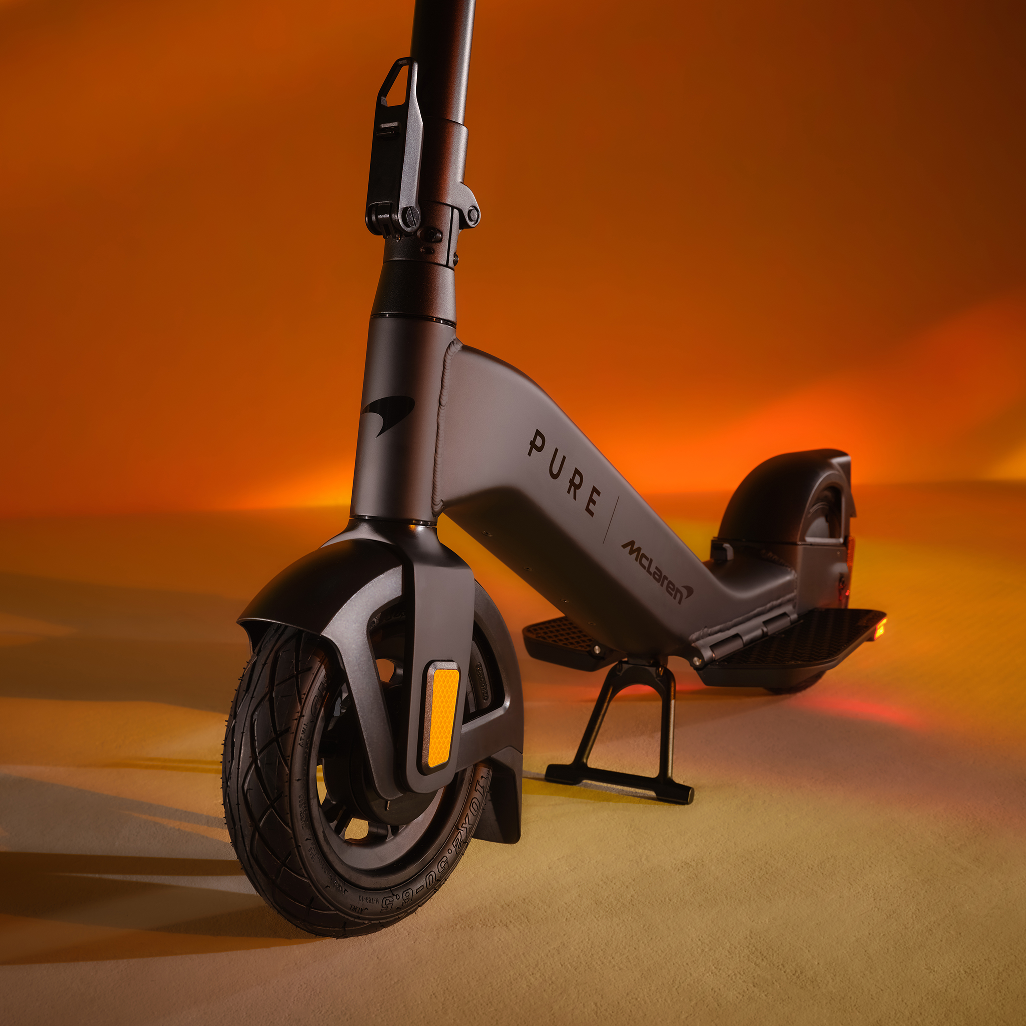 Schwarzer E-Scooter mit dem Schriftzug PURE McLaren auf orangem Hintergrund.