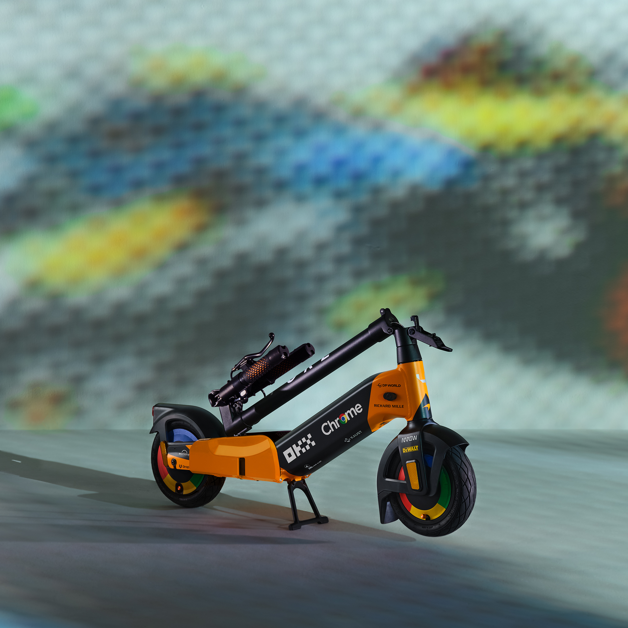 Ein orangefarber E-Scooter mit schwarzen Akzenten steht auf einem grauen Untergrund.