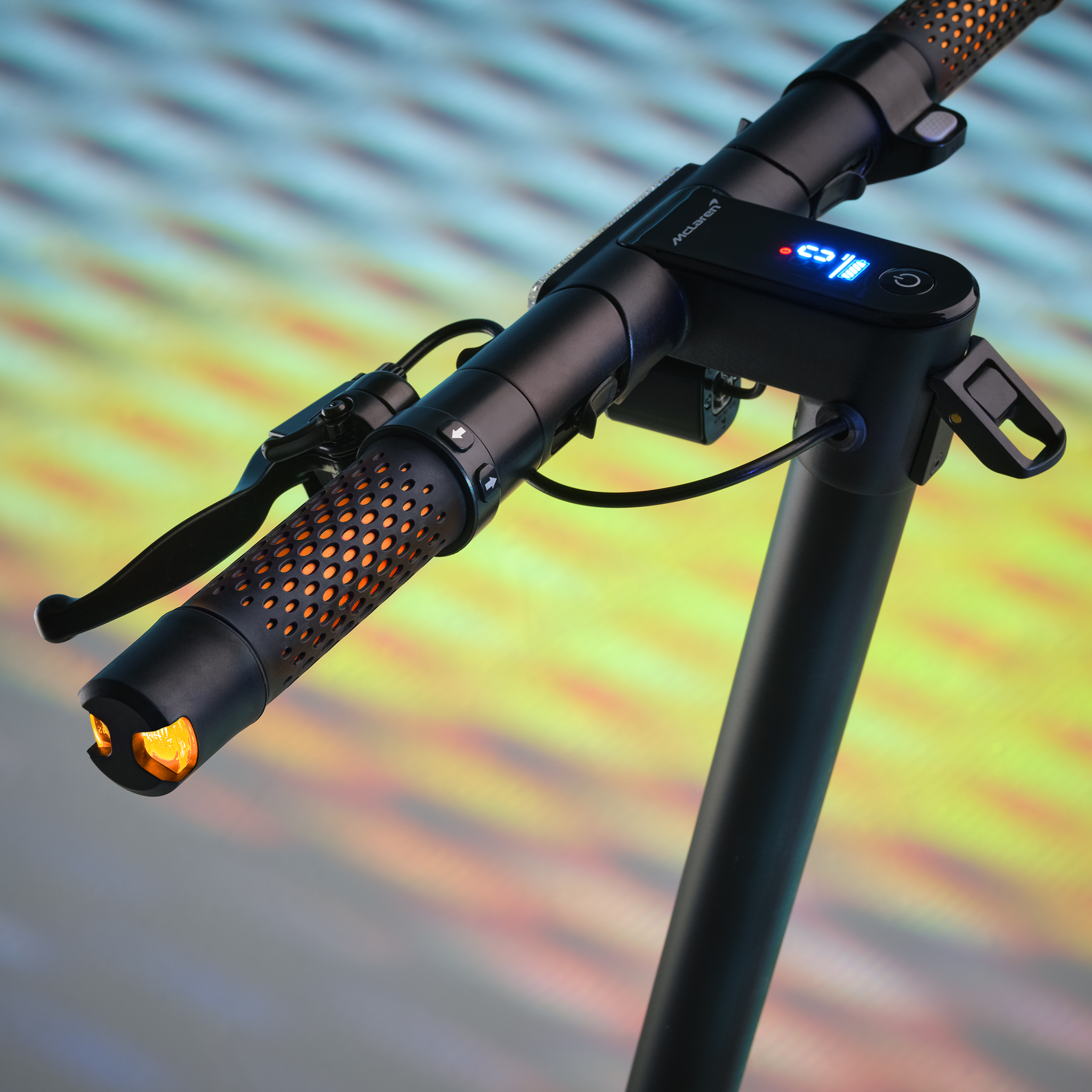Nahaufnahme des Lenkers eines schwarzen Elektrorollers mit orangen Akzenten.
