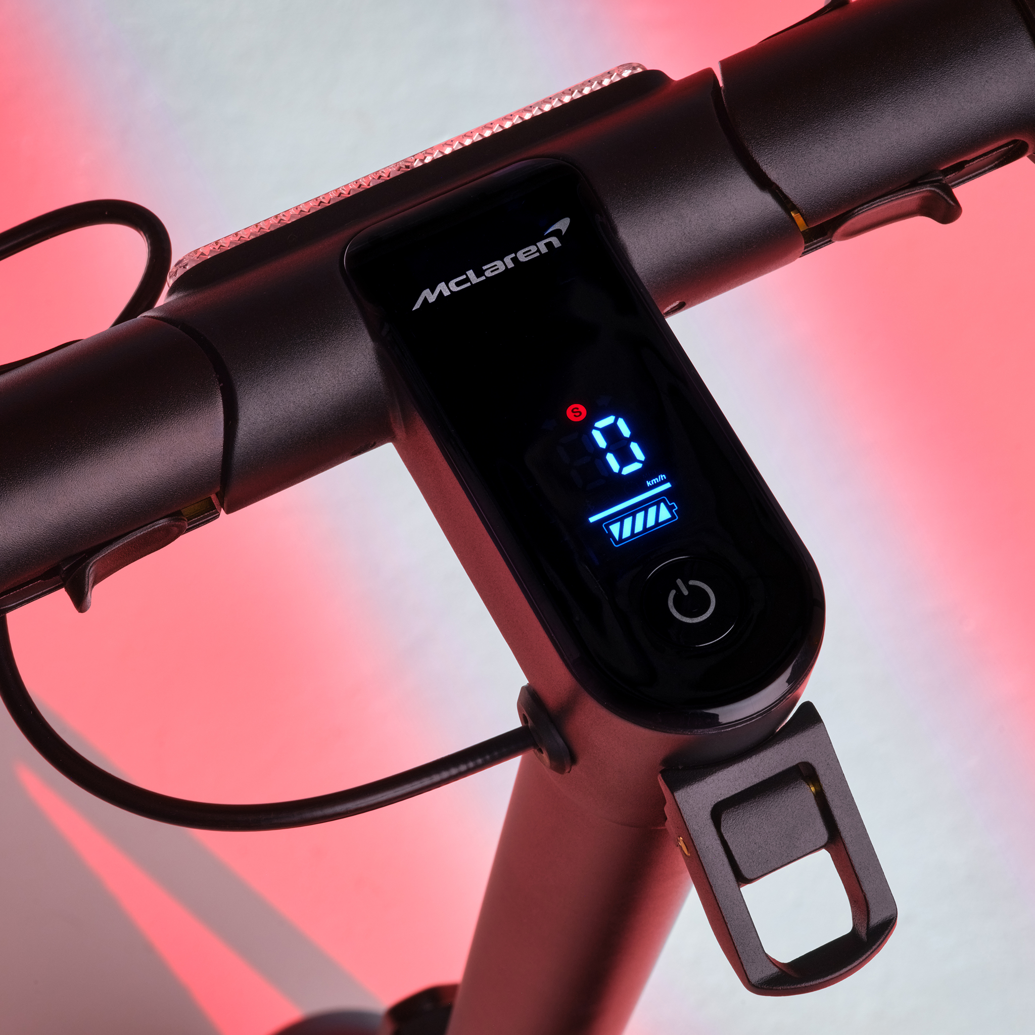 McLaren-Logo auf schwarzem Rollerdisplay mit 0 km/h und Akku. Rotes Licht.